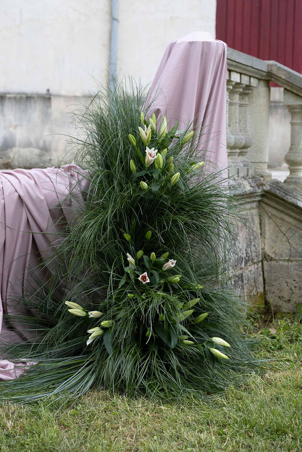 White and blush tulip bridal bouquet with ornamental grass at historic garden estate