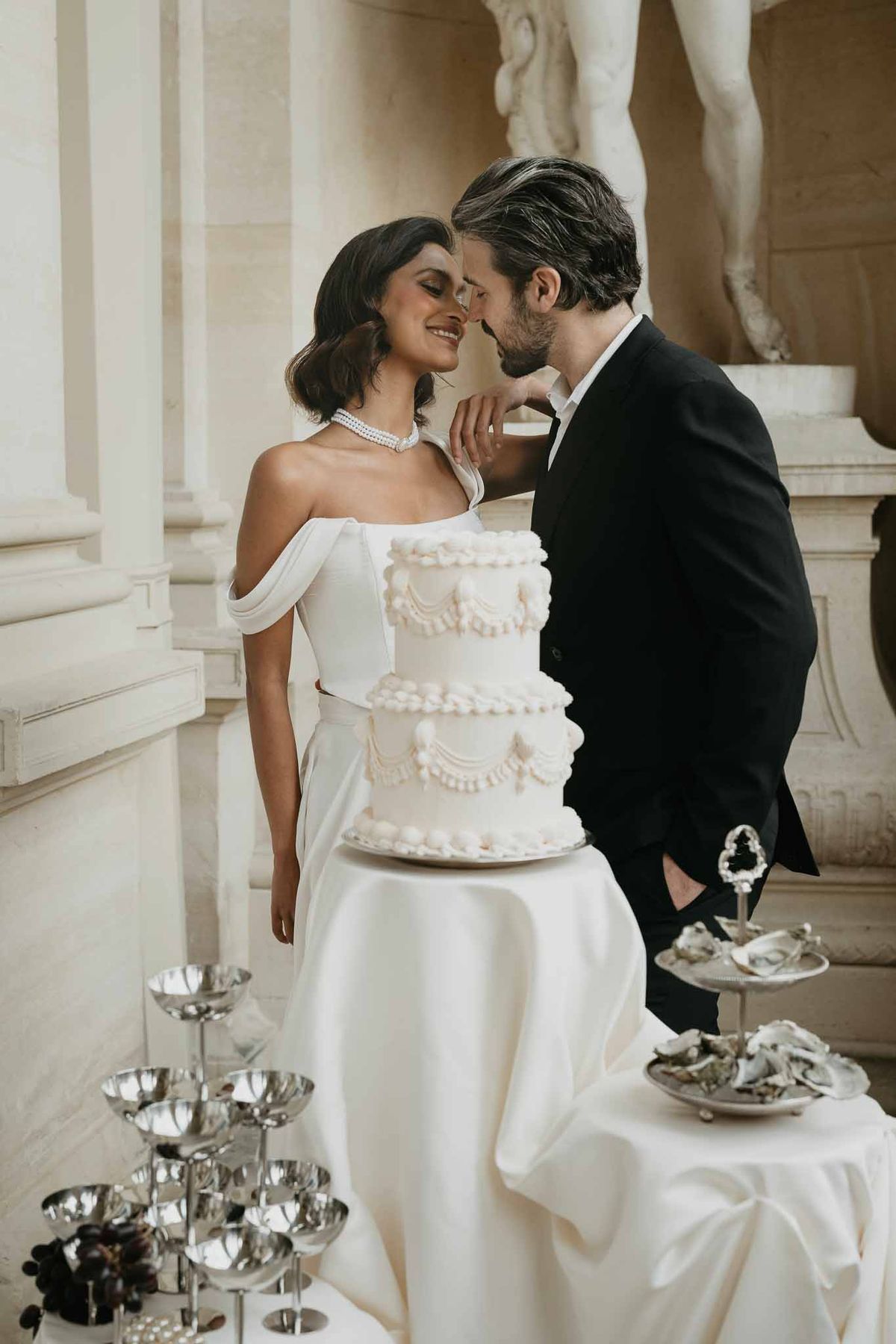 Bride and groom cutting wedding cake at elegant indoor reception venue