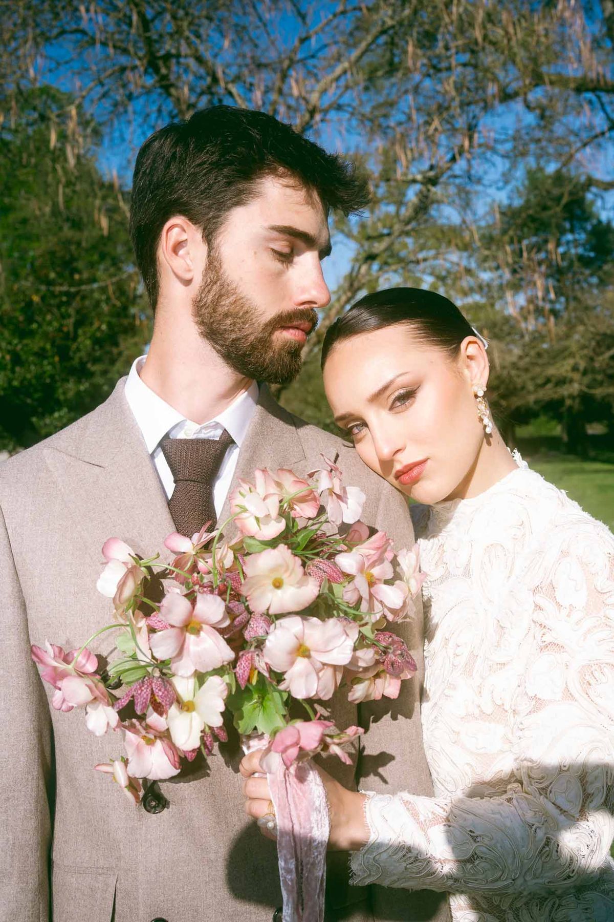 Bride and groom holding bouquet in intimate outdoor portrait at garden setting