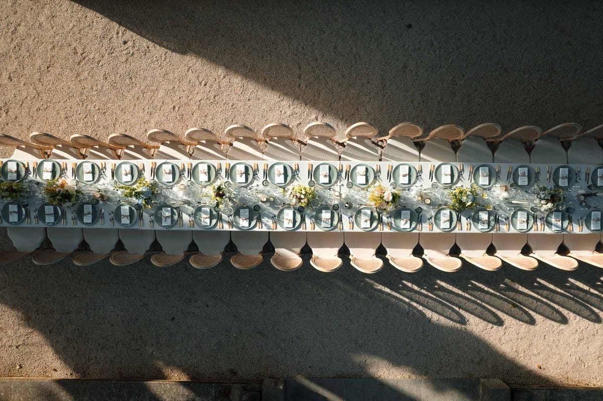 Aerial view of outdoor reception table setting with natural linens and teal napkins
