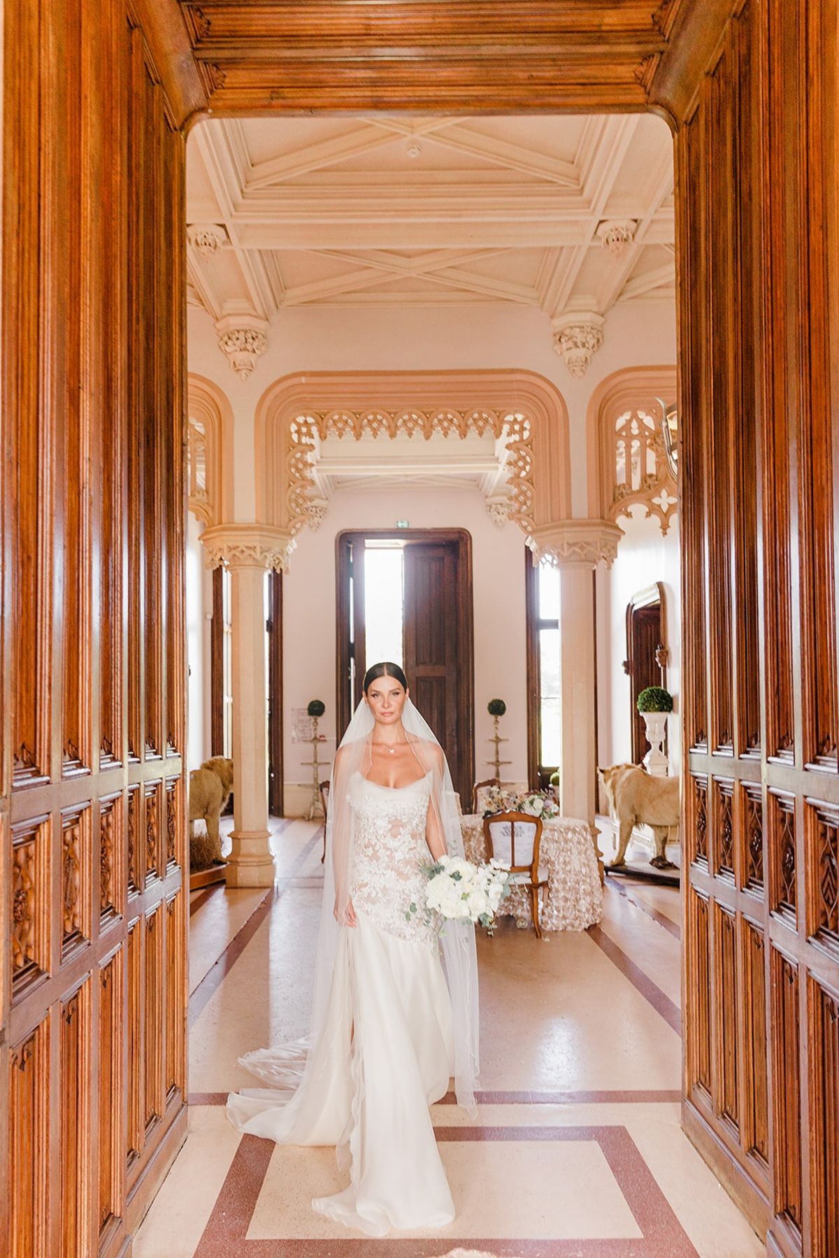 Bride with bouquet in chateau hallway at Chateau Challain, Loire Valley