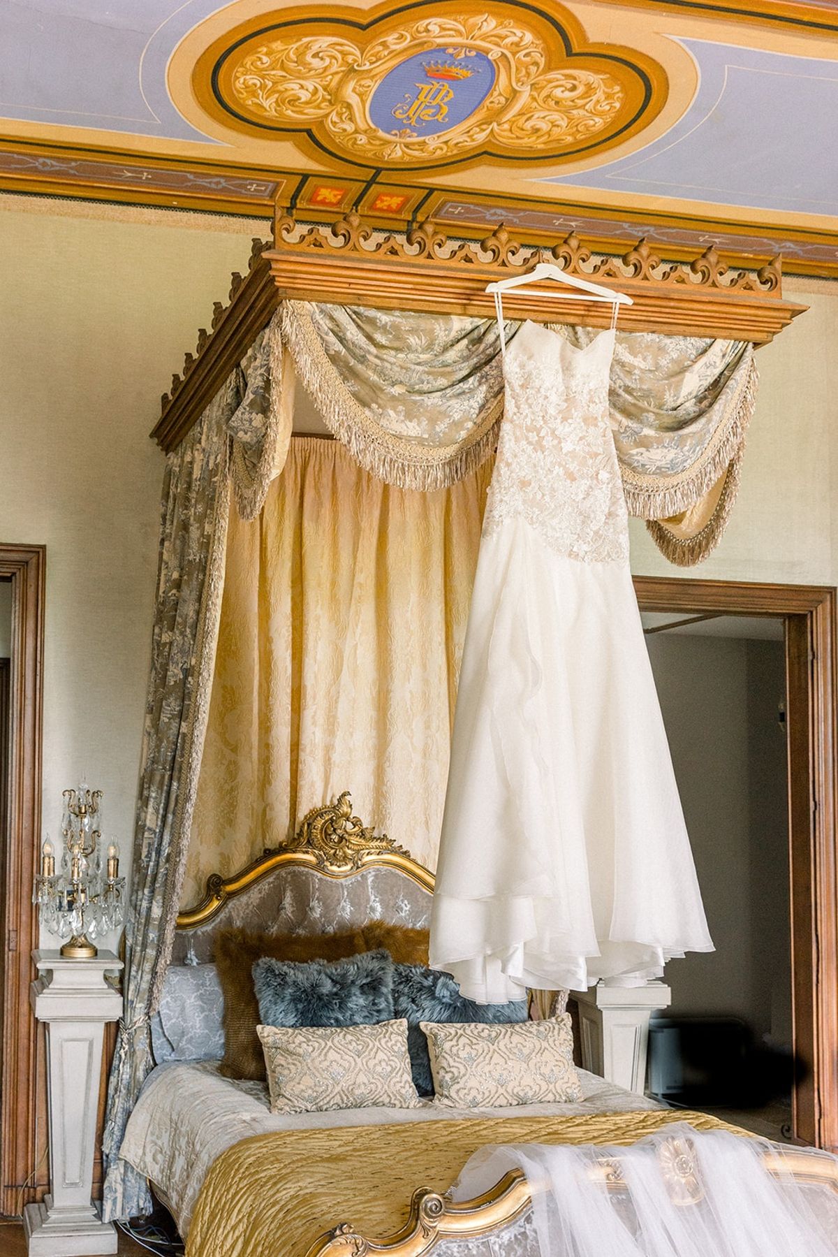 Wedding dress hanging in vintage bedroom at Chateau Challain, Loire Valley