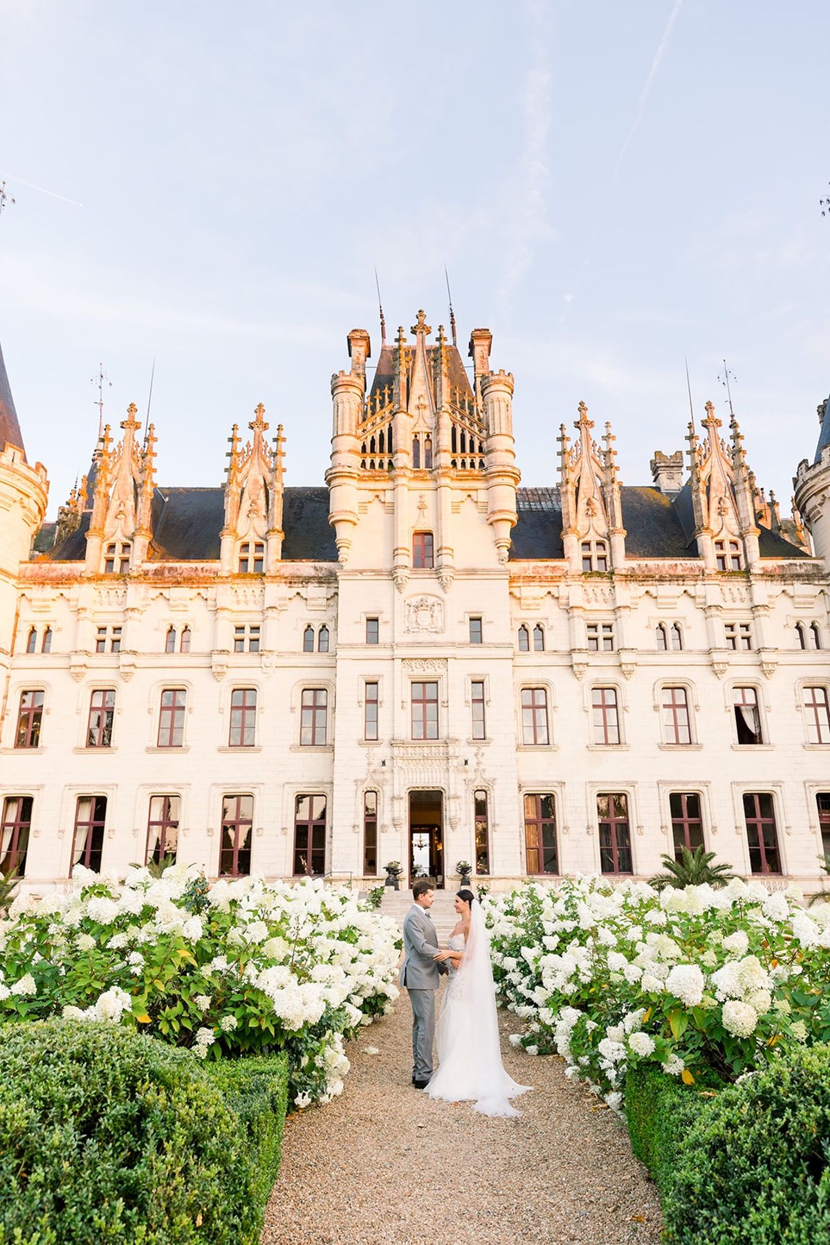 Couple holding hands in hydrangea garden at Chateau Challain, Loire Valley