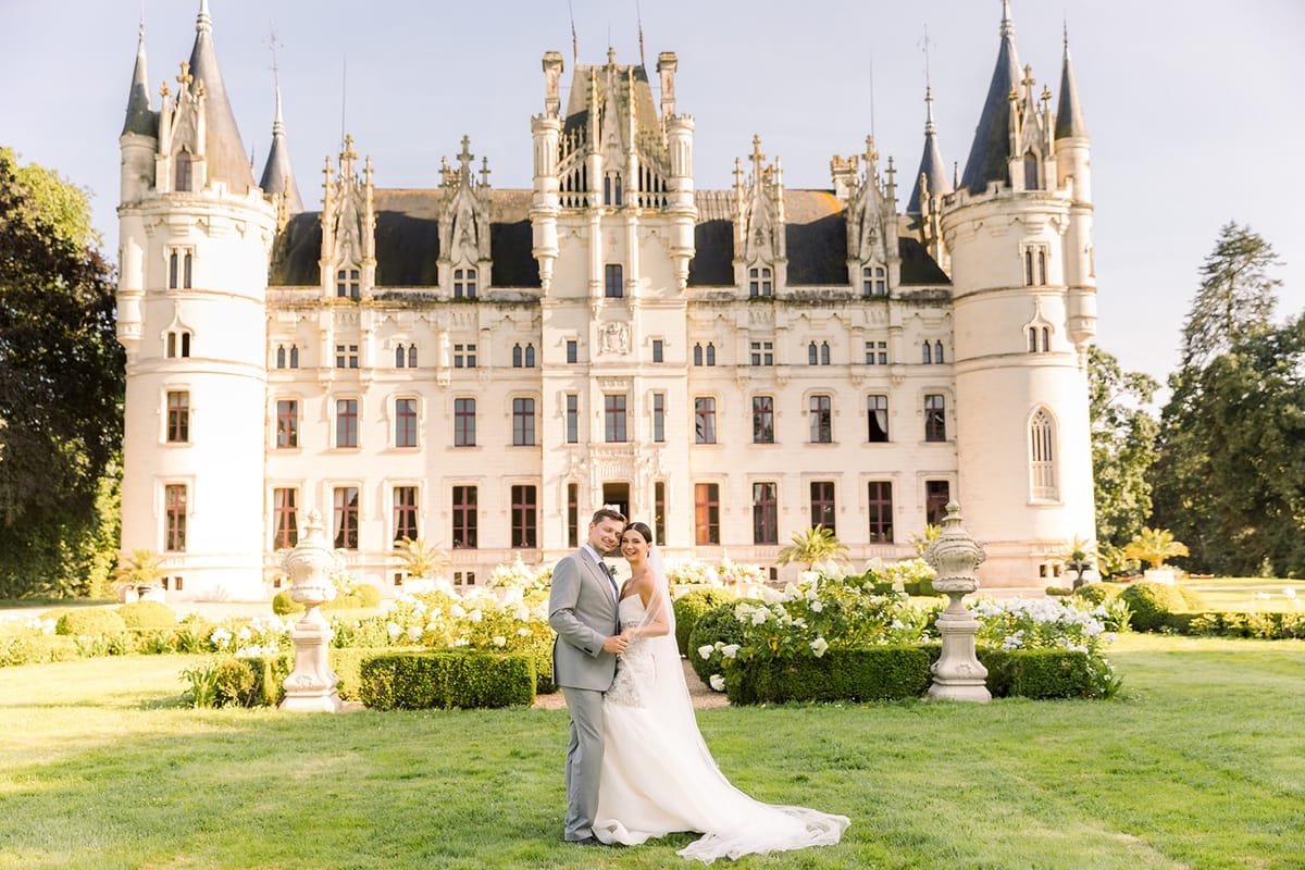 Couple cheek to cheek in front of chateau facade at Chateau Challain, Loire Valley