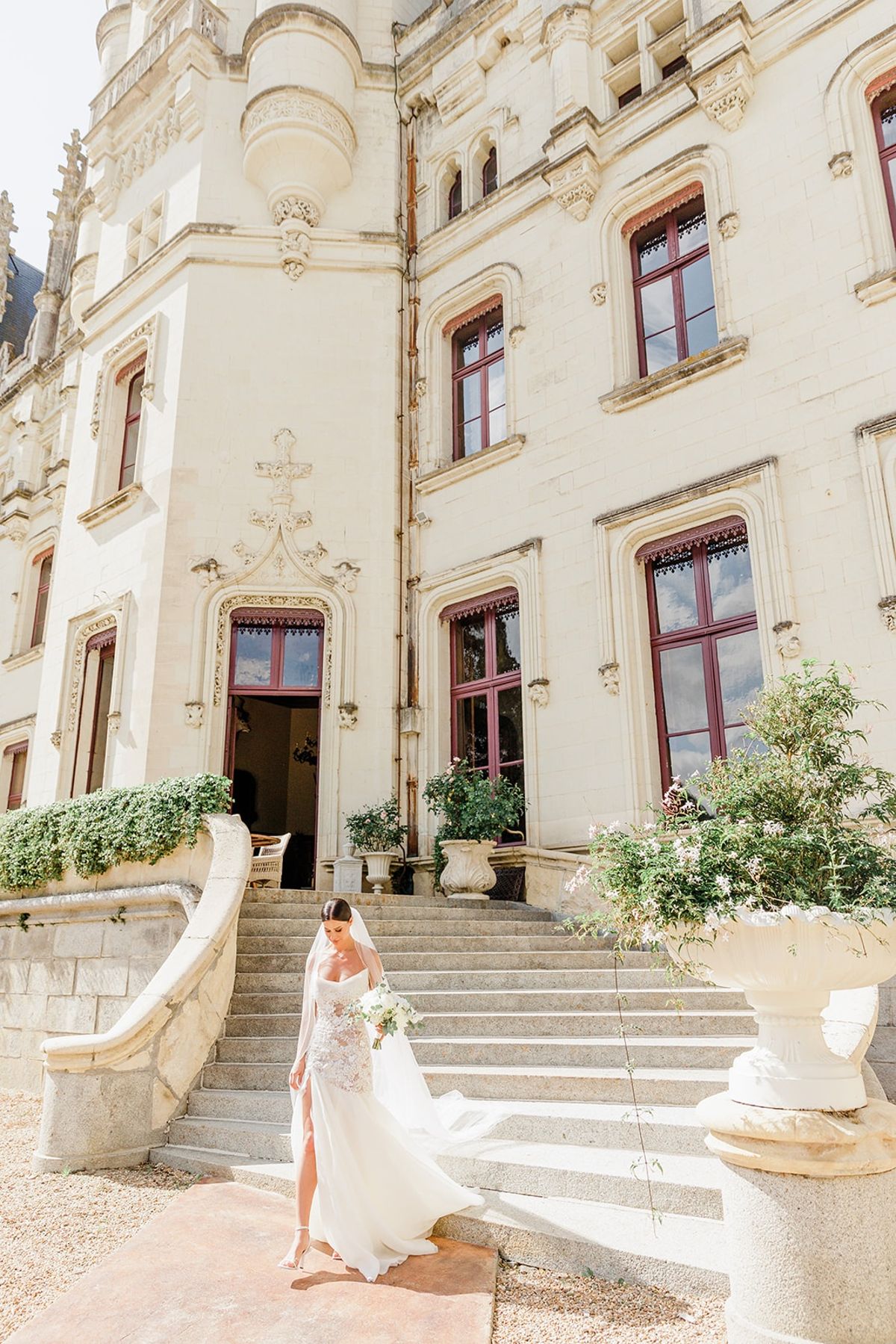 Bride descending carved stone staircase at Chateau Challain, Loire Valley