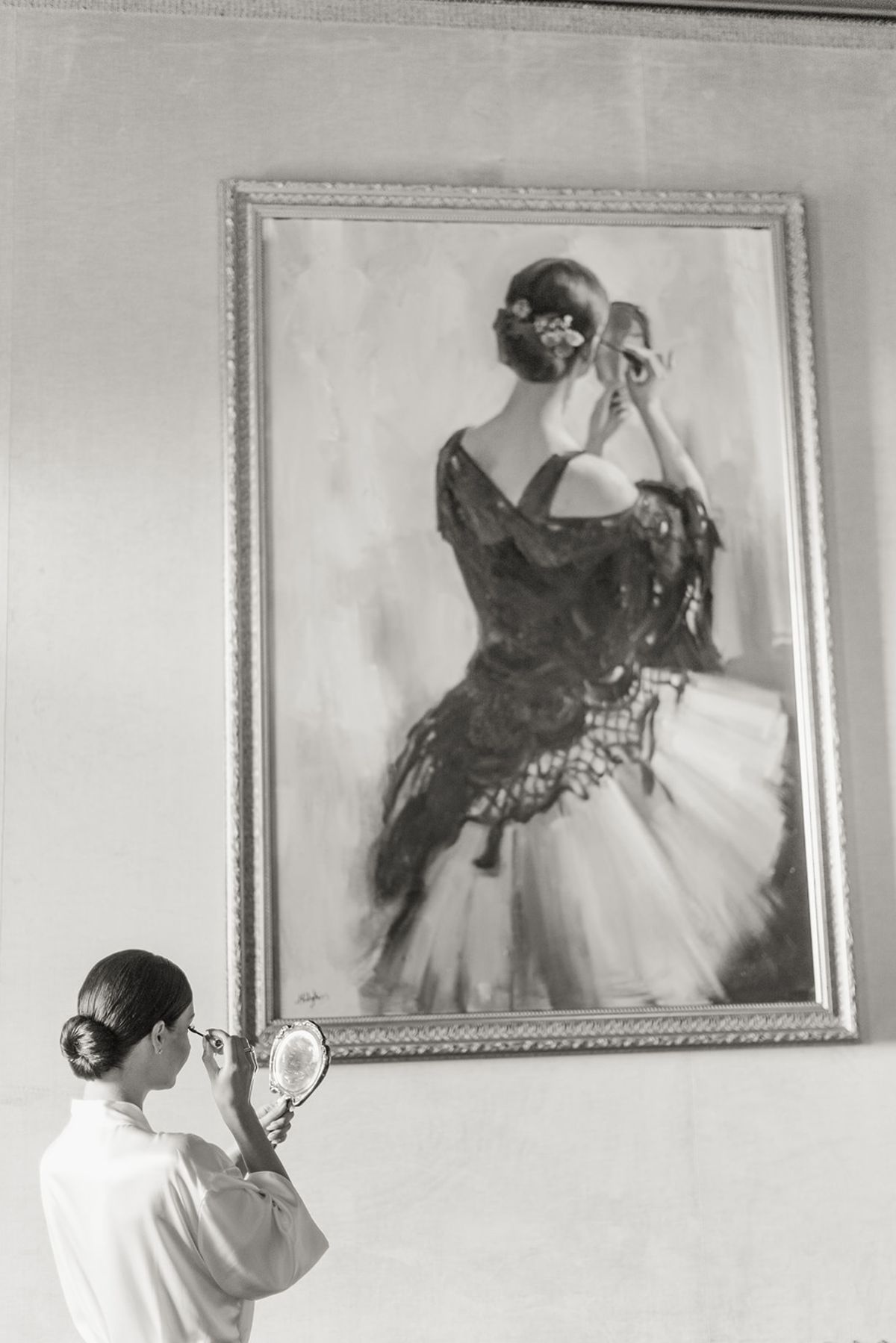 Bride checking makeup in vintage hand mirror at Chateau Challain, Loire Valley