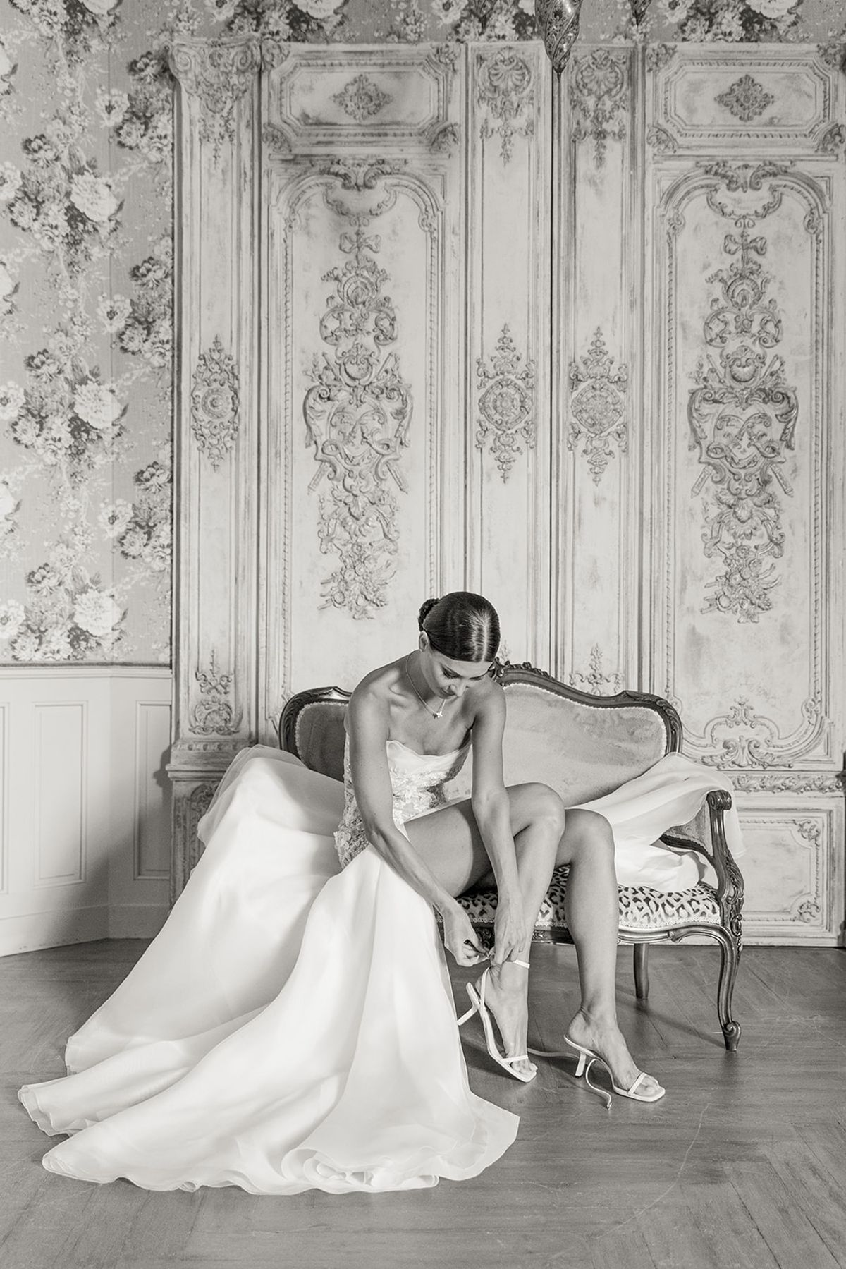 Bride fastening shoe on vintage settee at Chateau Challain, Loire Valley