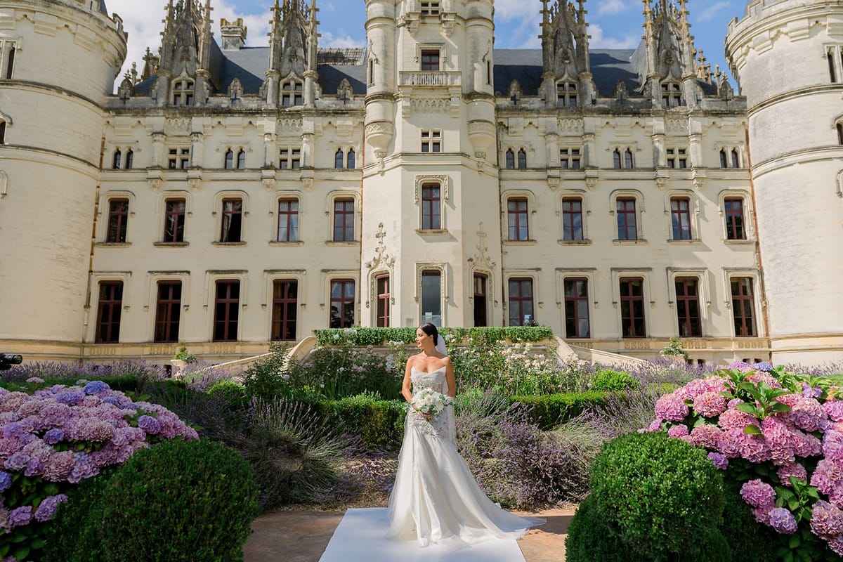 Bride in lavender parterre before chateau facade at Chateau Challain, Loire Valley