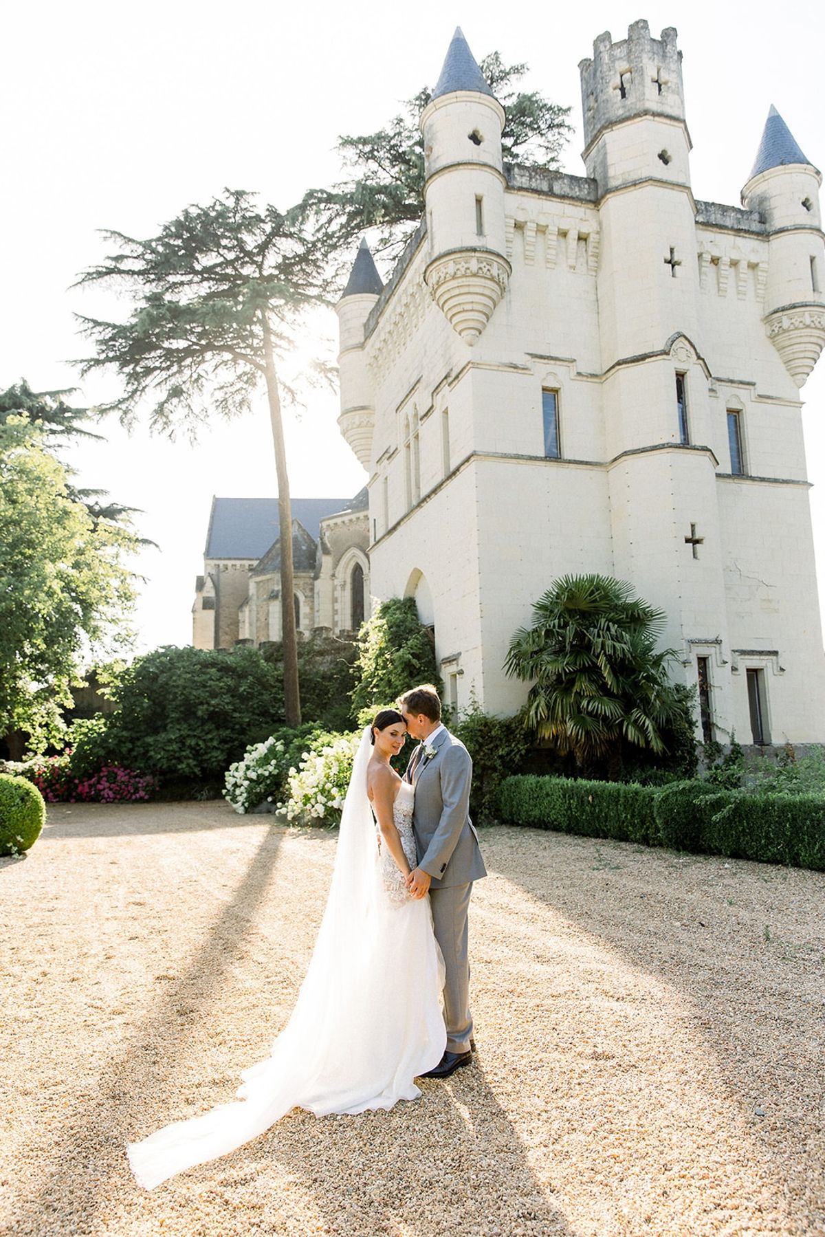 Couple embracing in golden hour beside chateau turret at Chateau Challain, Loire Valley