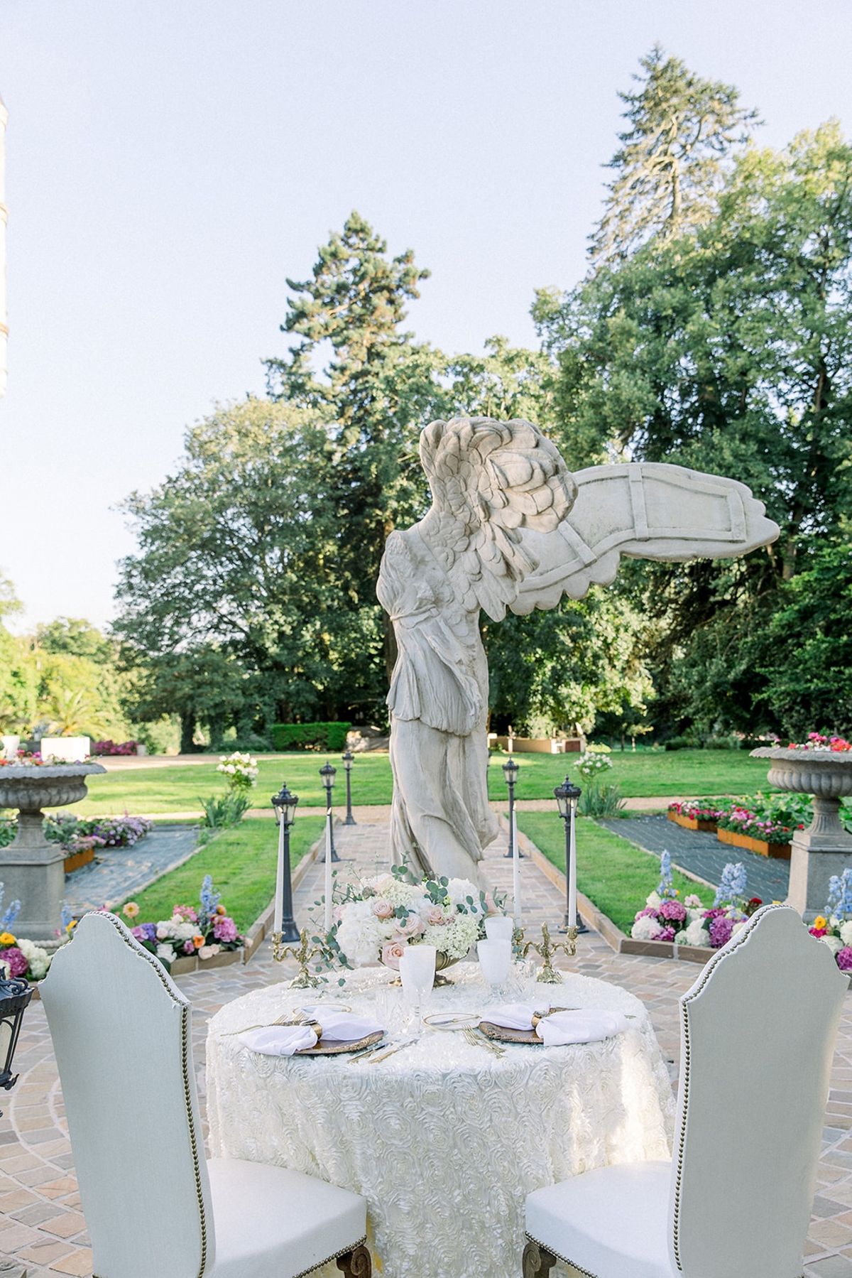 Sweetheart table for two beneath winged statue at Chateau Challain, Loire Valley