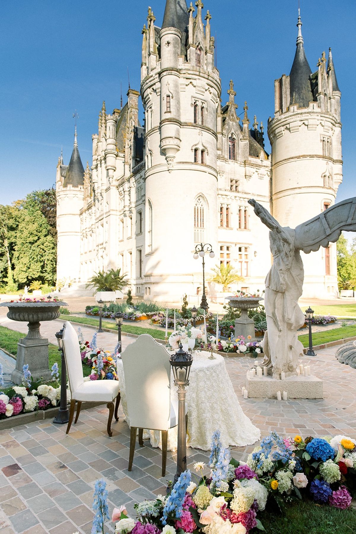 Sweetheart table with florals before chateau towers at Chateau Challain, Loire Valley