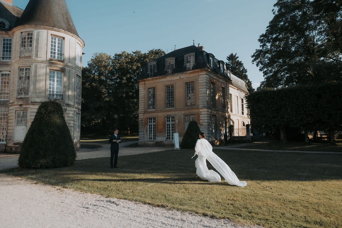 The bride on the lawn with the château and its tower behind her