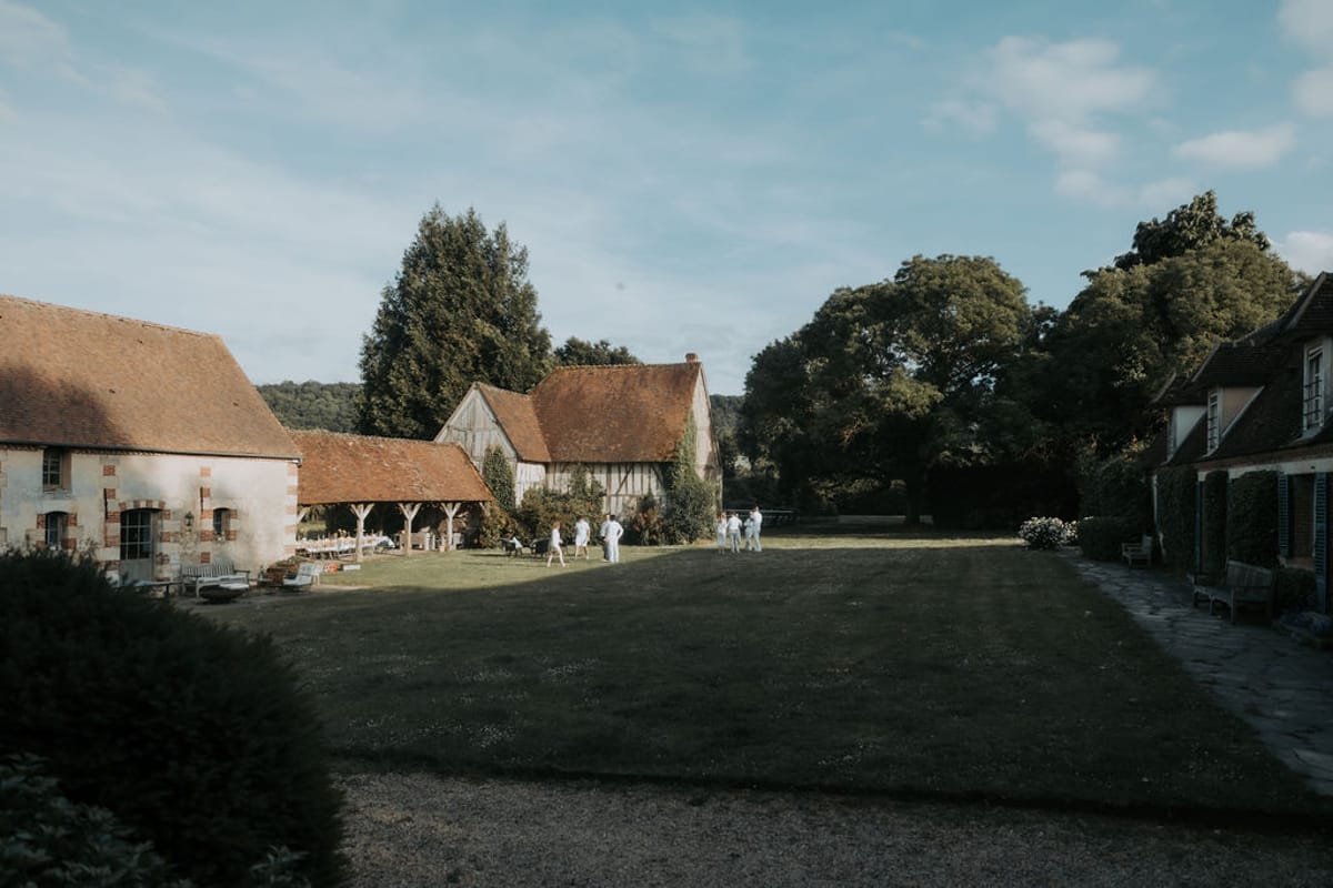 A half-timbered farmhouse and lawn in early evening light, the evening before the wedding
