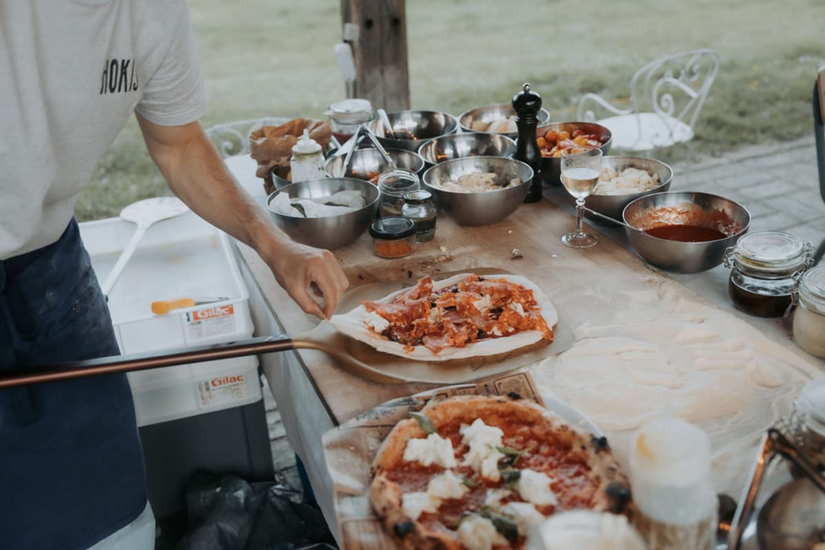 Pizzas being prepared at an outdoor table