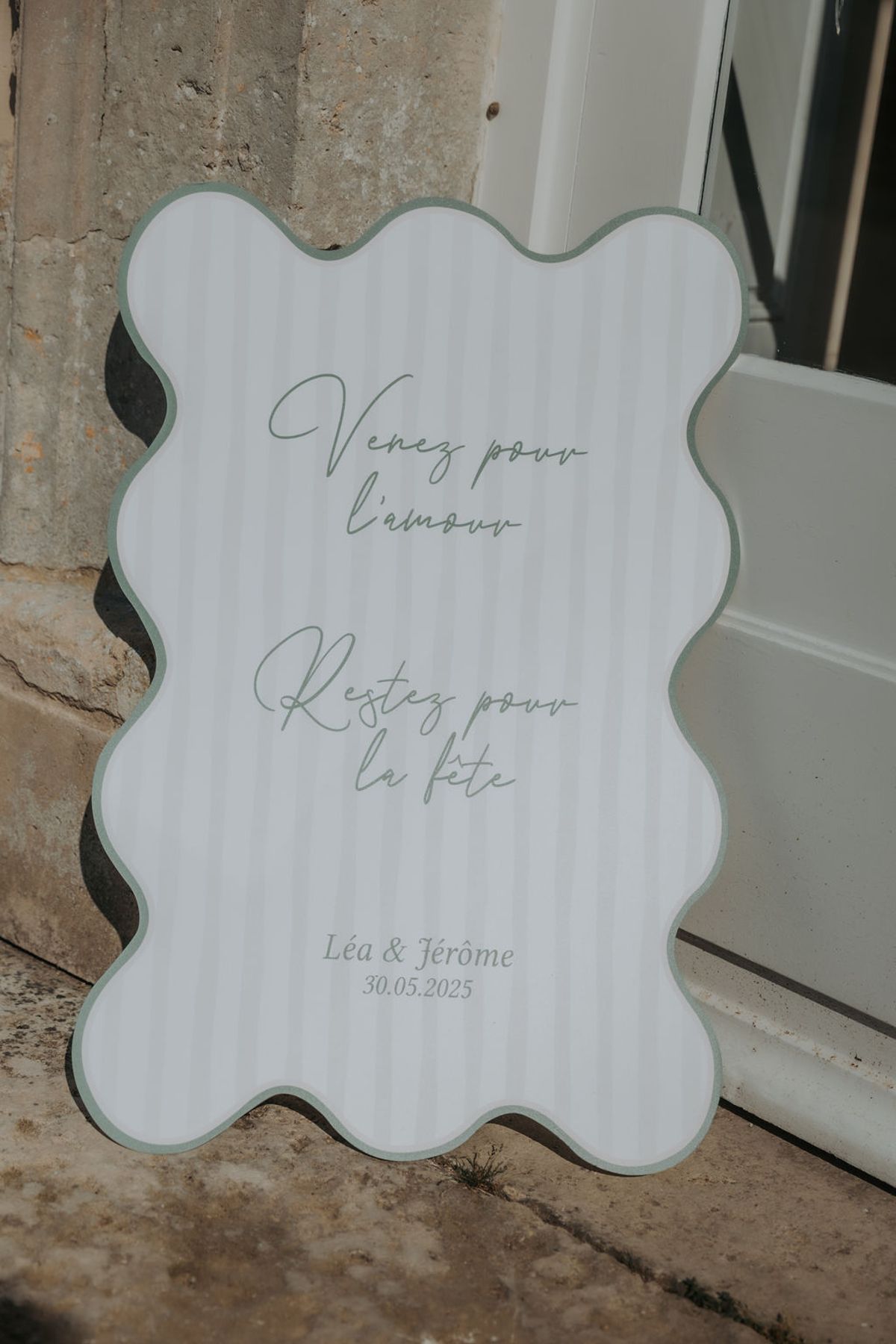 A wavy-edged sign with handwritten script and the couple's names