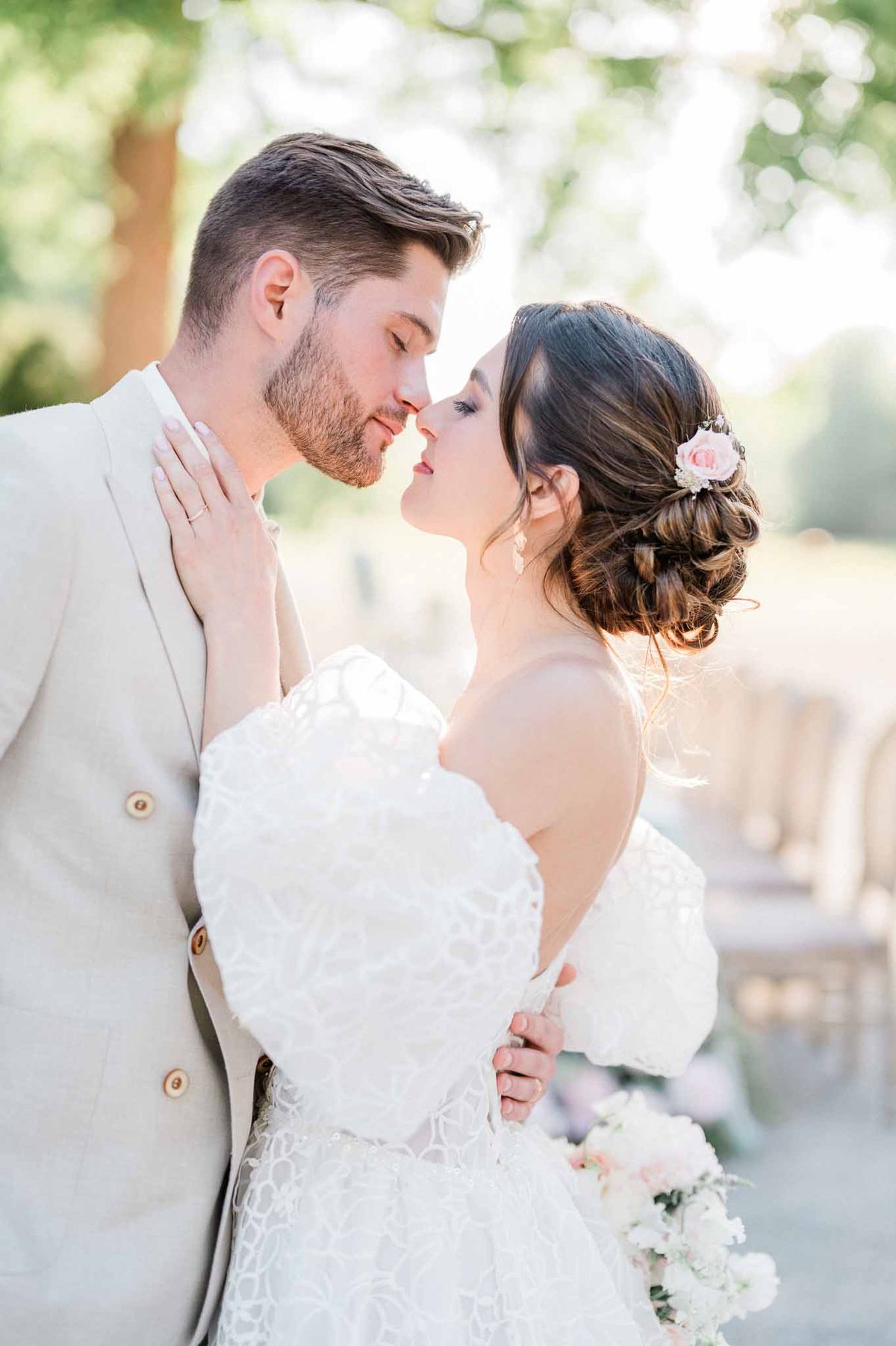 Bride and groom kissing during romantic garden portrait session at outdoor wedding venue