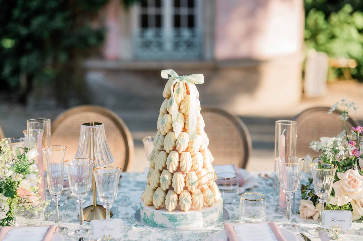 Croquembouche wedding cake and reception table setting at historic courtyard venue
