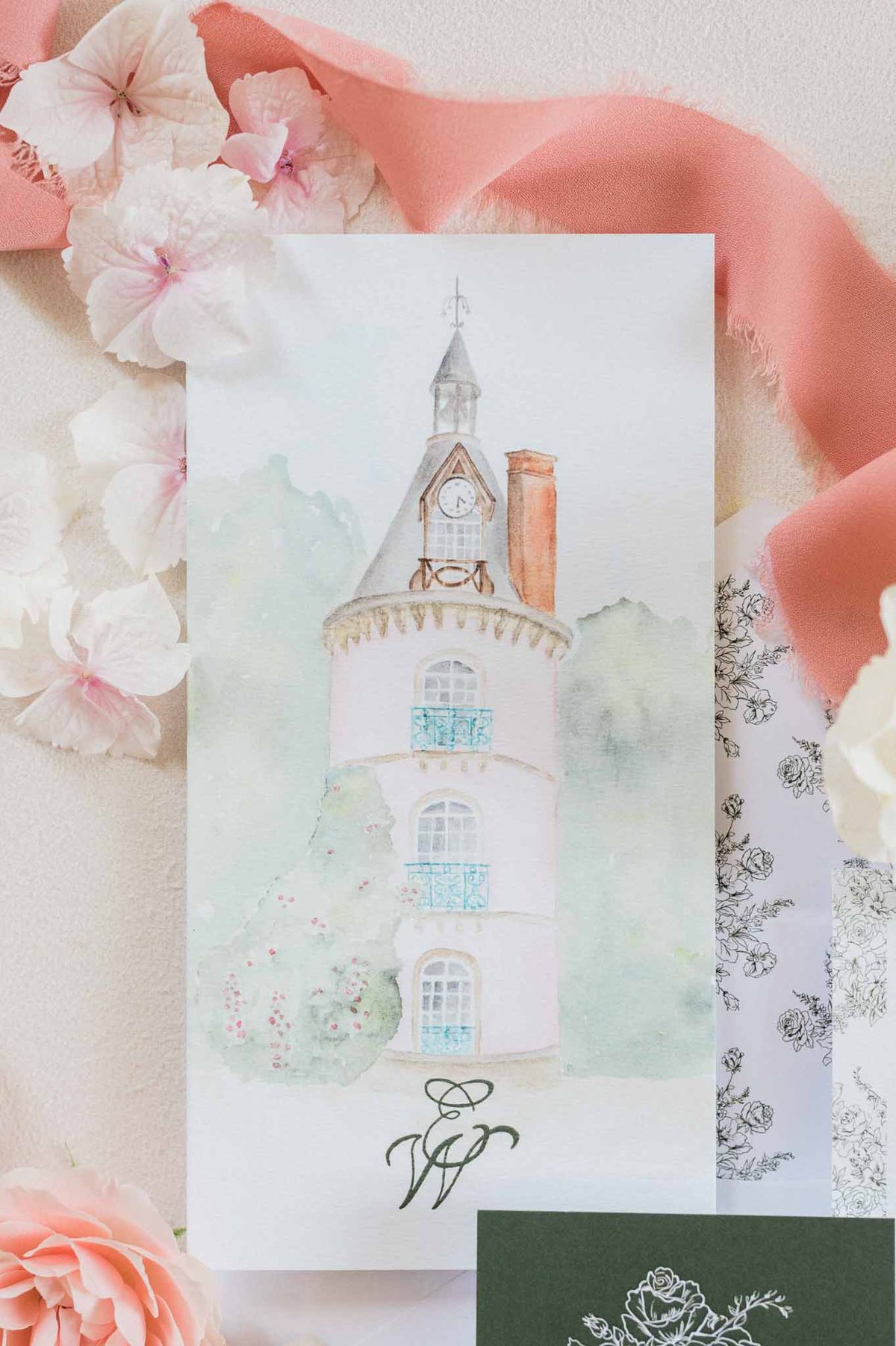 Wedding stationery flat lay with watercolor tower illustration, peonies, and silk ribbons
