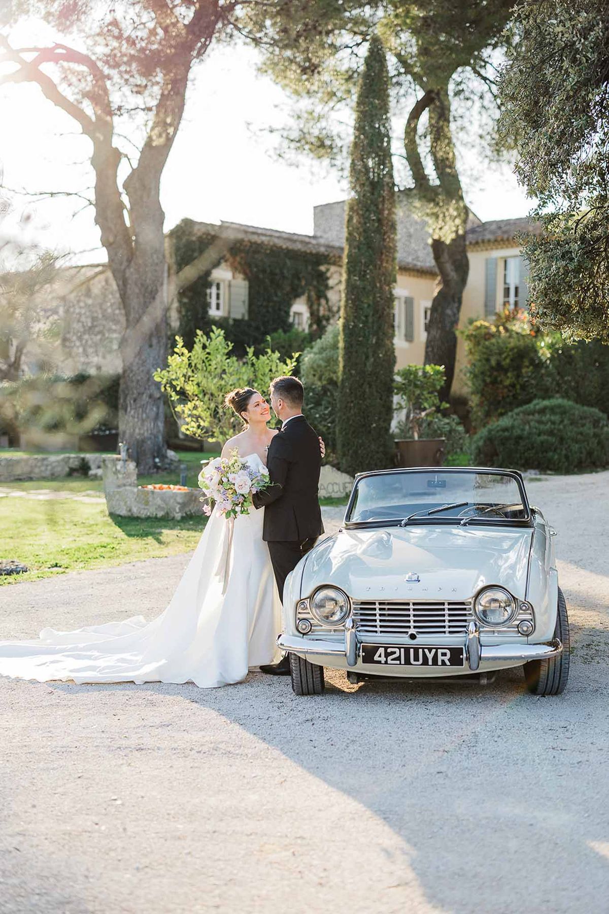 Bride and groom portrait with vintage convertible at Mediterranean estate wedding venue