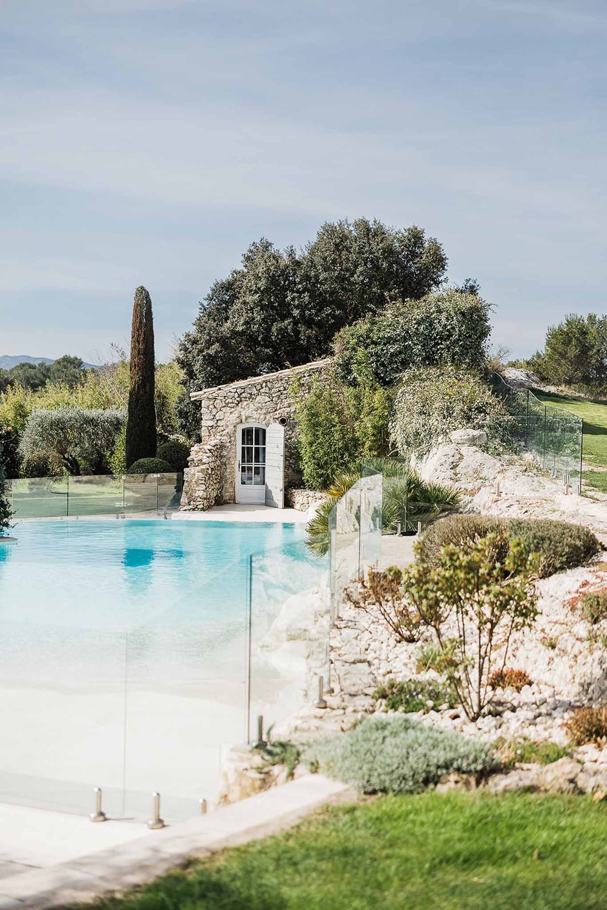 Resort-style infinity pool with stone pool house and Mediterranean landscaping at wedding venue