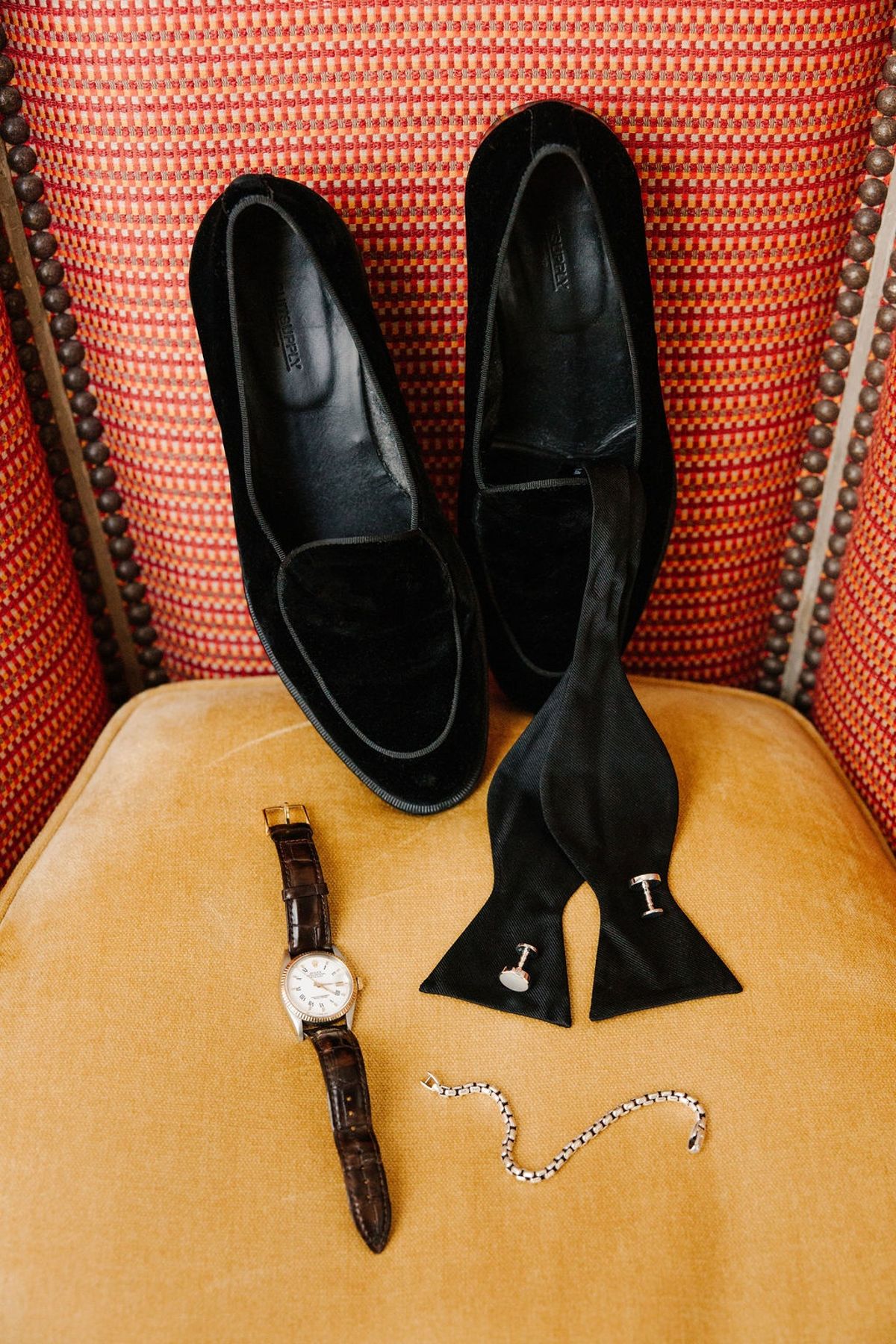 Groom's black velvet loafers, watch and bow tie at Airelles Gordes La Bastide, Provence