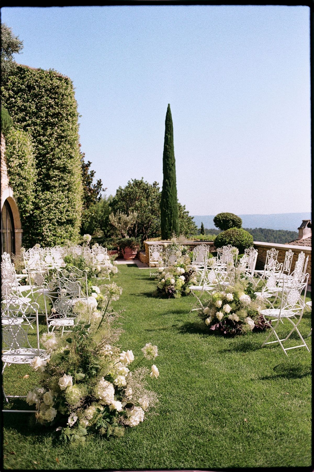 Empty ceremony aisle with hydrangeas and cypress at Airelles Gordes La Bastide, Provence