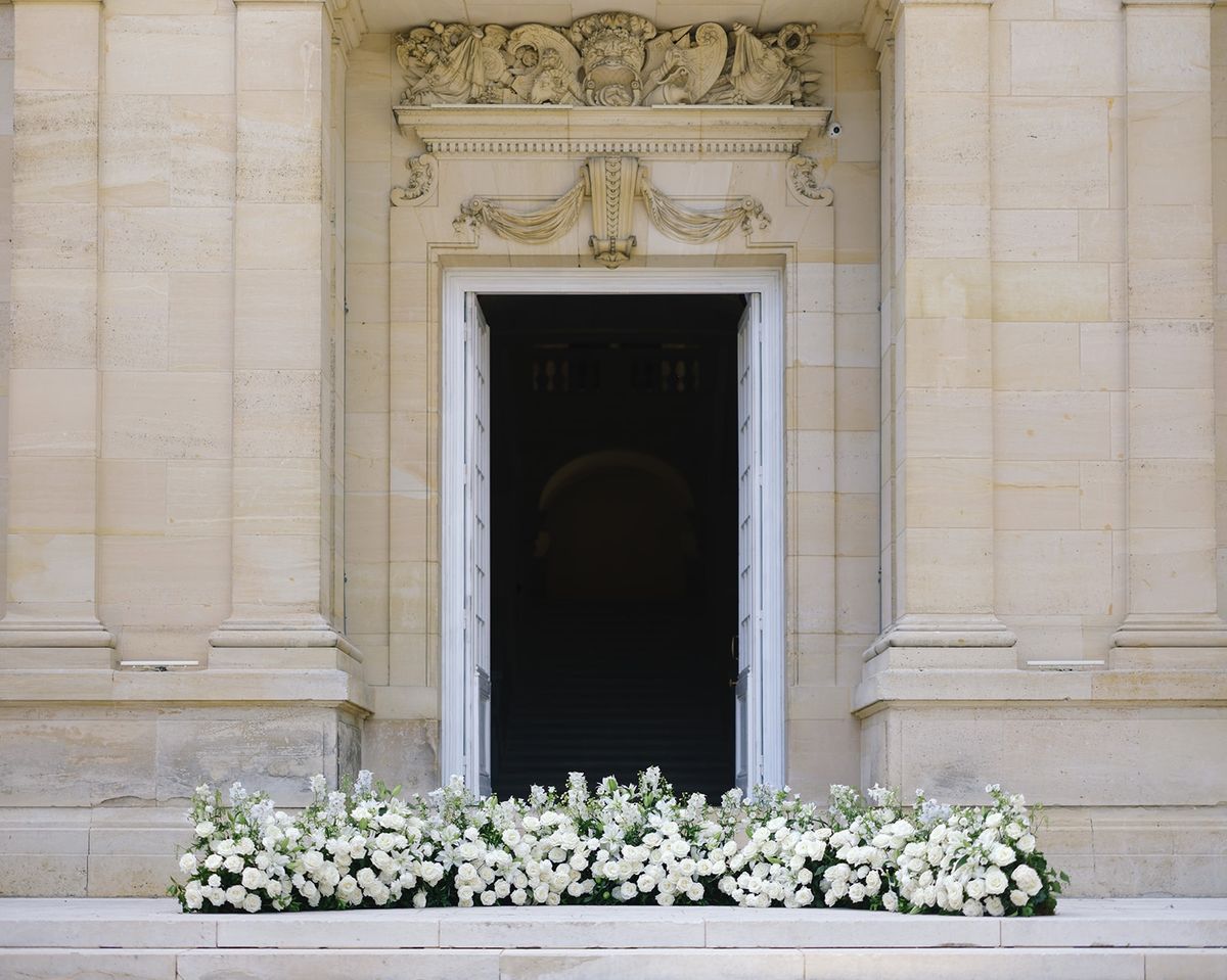 Chateau doorway with white rose carpet at Chateau Saint-Martin-du-Tertre