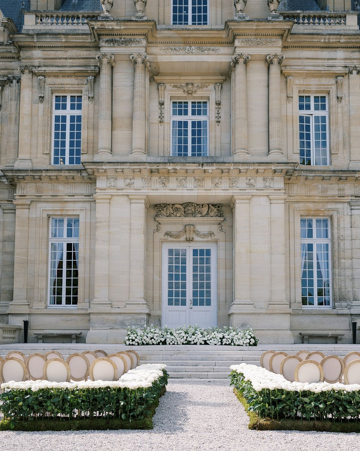 Chateau facade with white rose borders at Chateau Saint-Martin-du-Tertre
