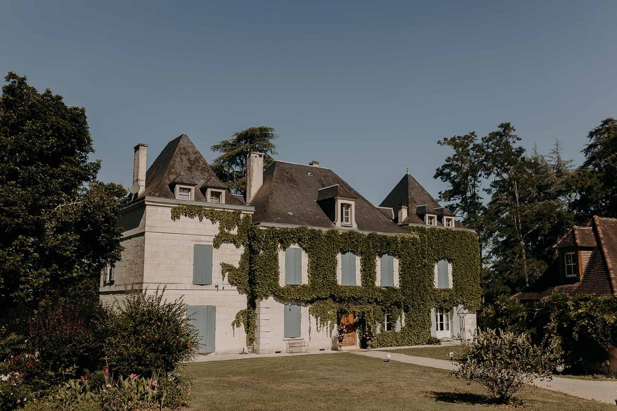 Ivy-covered château with blue shutters at Domaine de la Fauconnie
