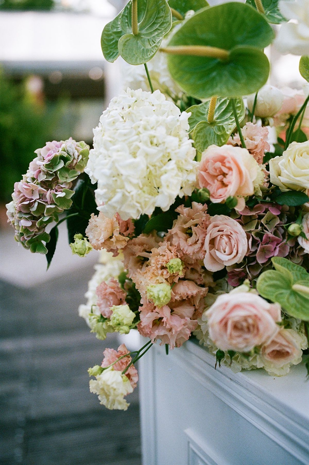 Close-up of a blush and cream floral arrangement with anthurium and garden roses