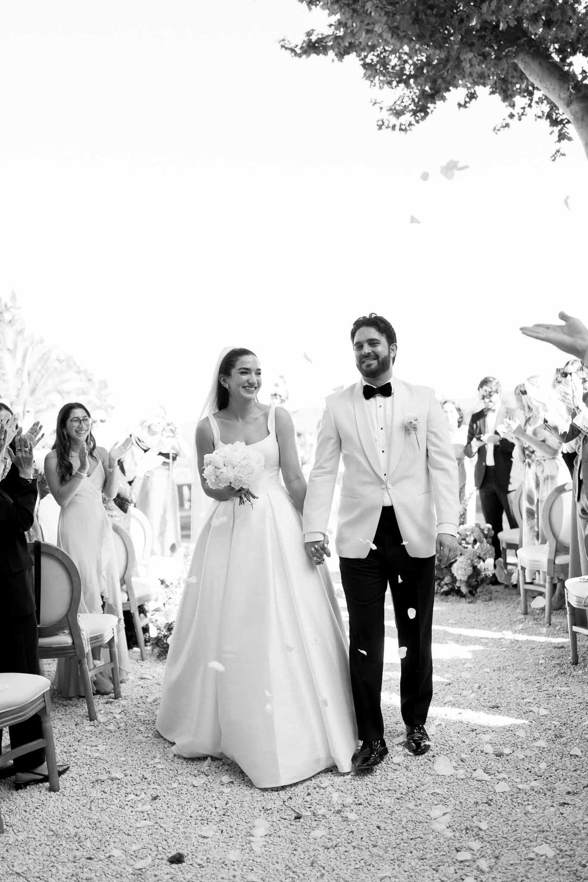 Black and white recessional with petal toss and guests applauding in Louis XVI chairs