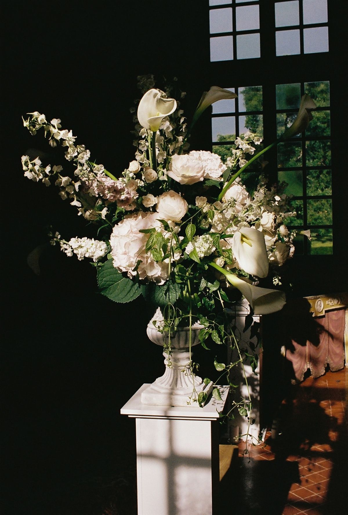 Analog close-up of ivory and blush ceremony arrangement of calla lilies and roses