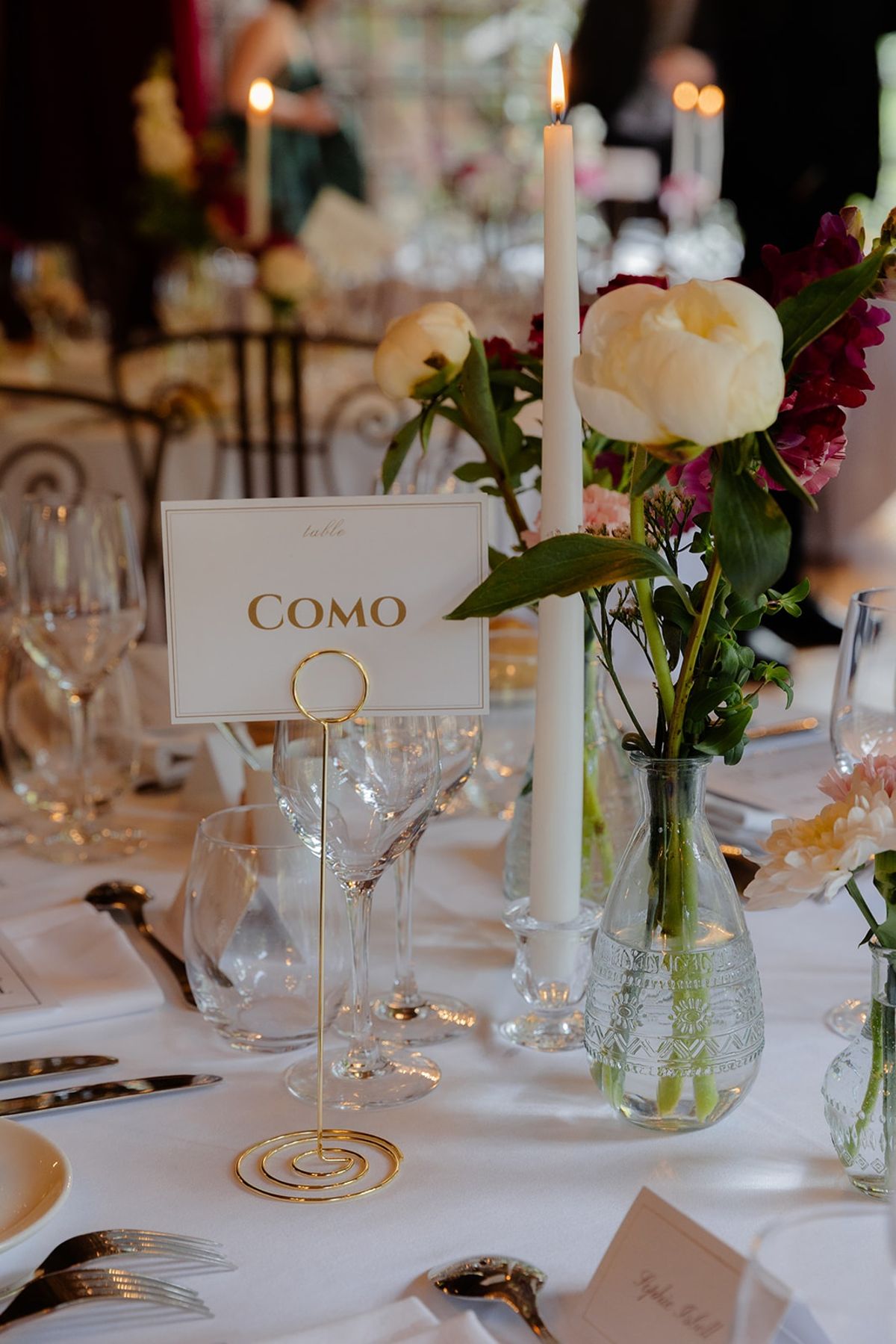 Gold spiral table number Como among peony bud vases and tapers on dinner table