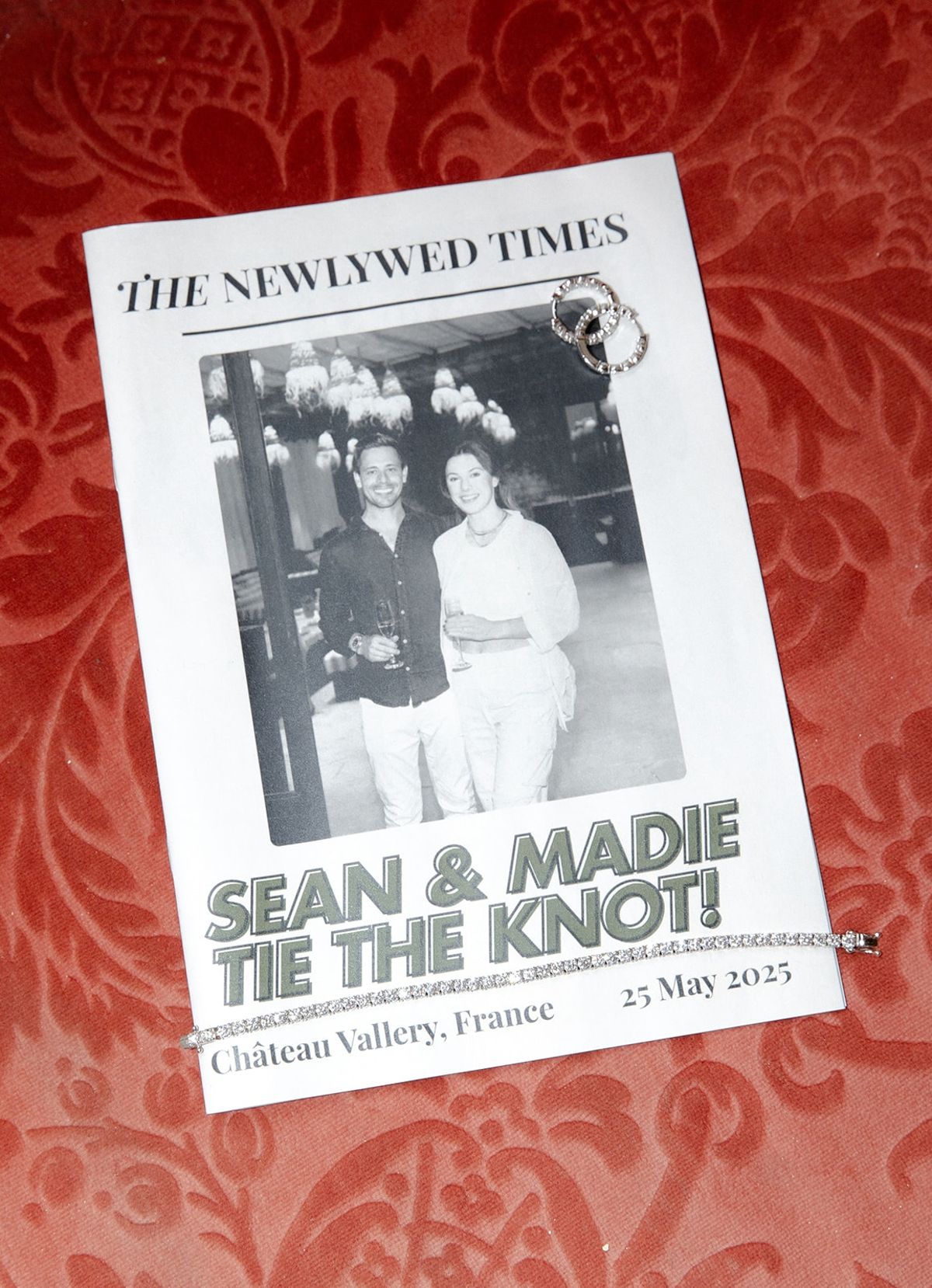 Newspaper-style wedding program with cover photograph on damask backdrop