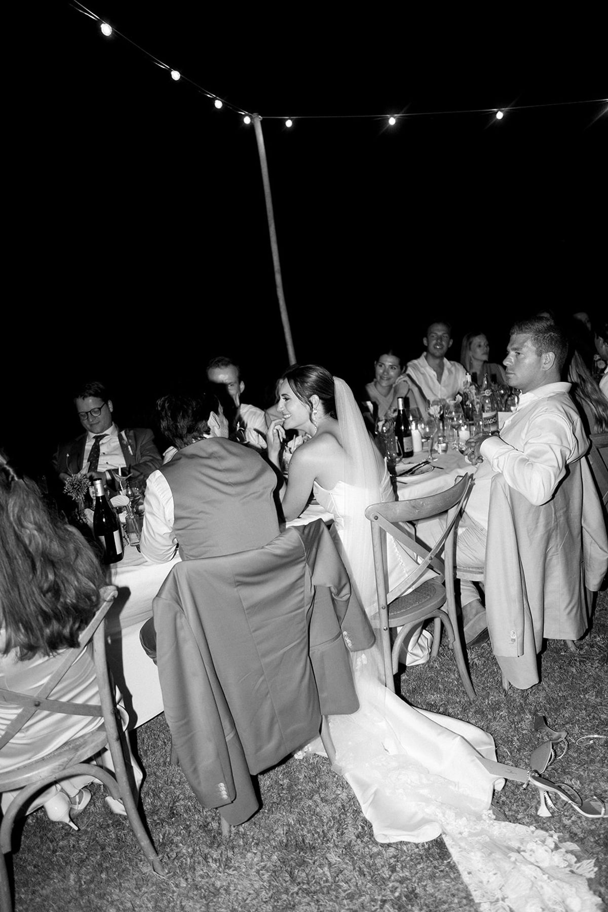 Couple seated at long reception dinner table at night at Les Domaines de Patras, Provence