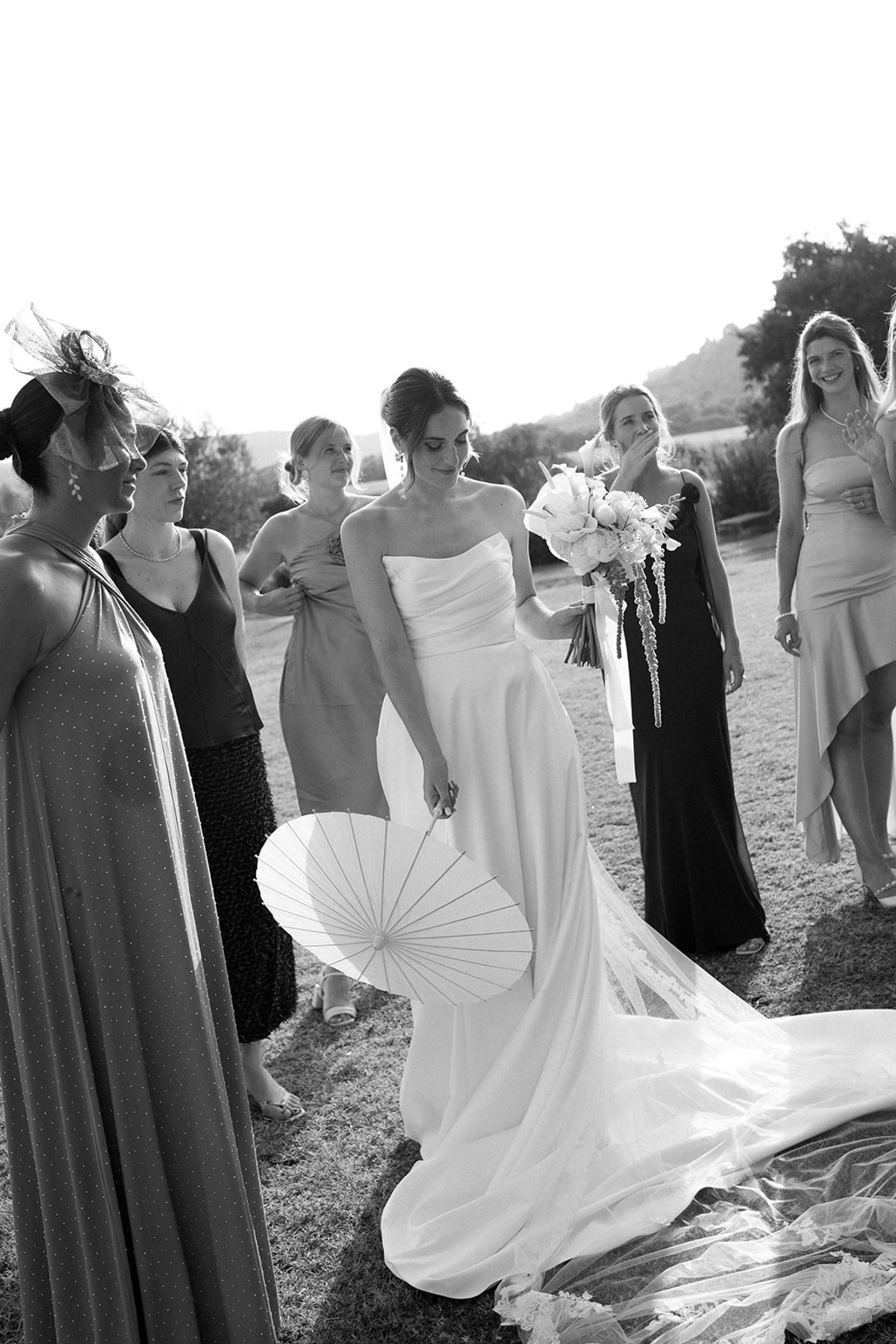 Bride with paper parasol surrounded by friends at Les Domaines de Patras, Provence