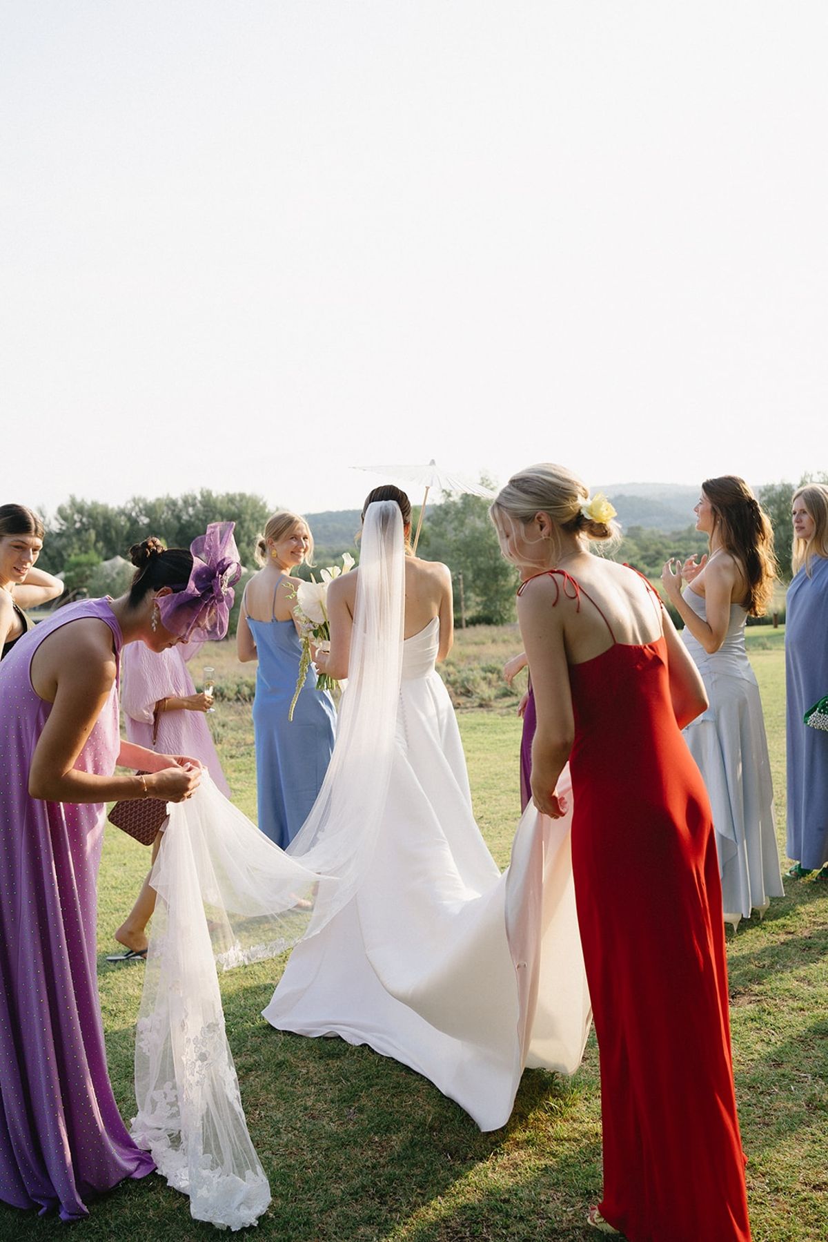 Bride with parasol and friends in coloured dresses at Les Domaines de Patras, Provence