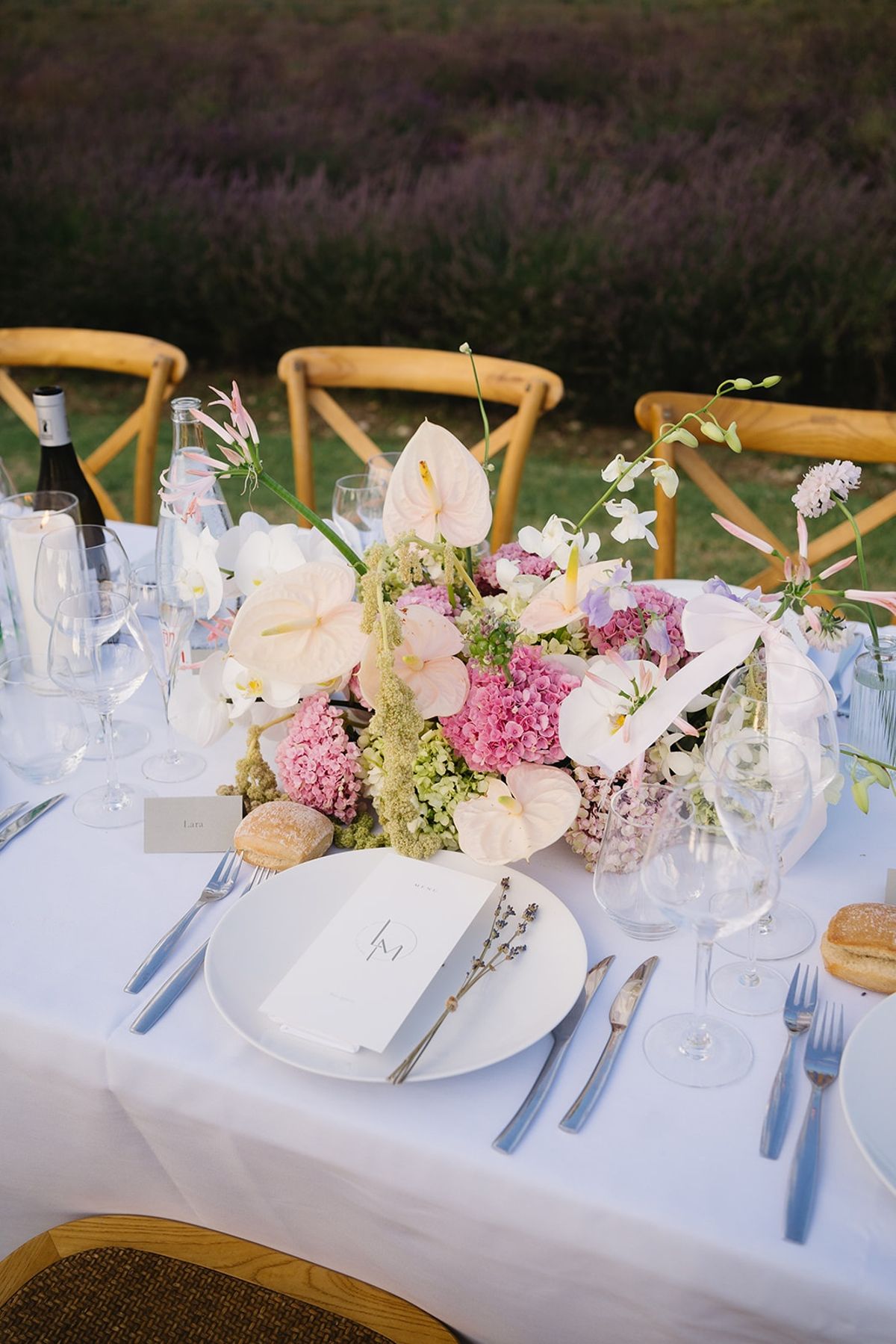 Place setting with menu and lavender beside floral centerpiece at Les Domaines de Patras, Provence
