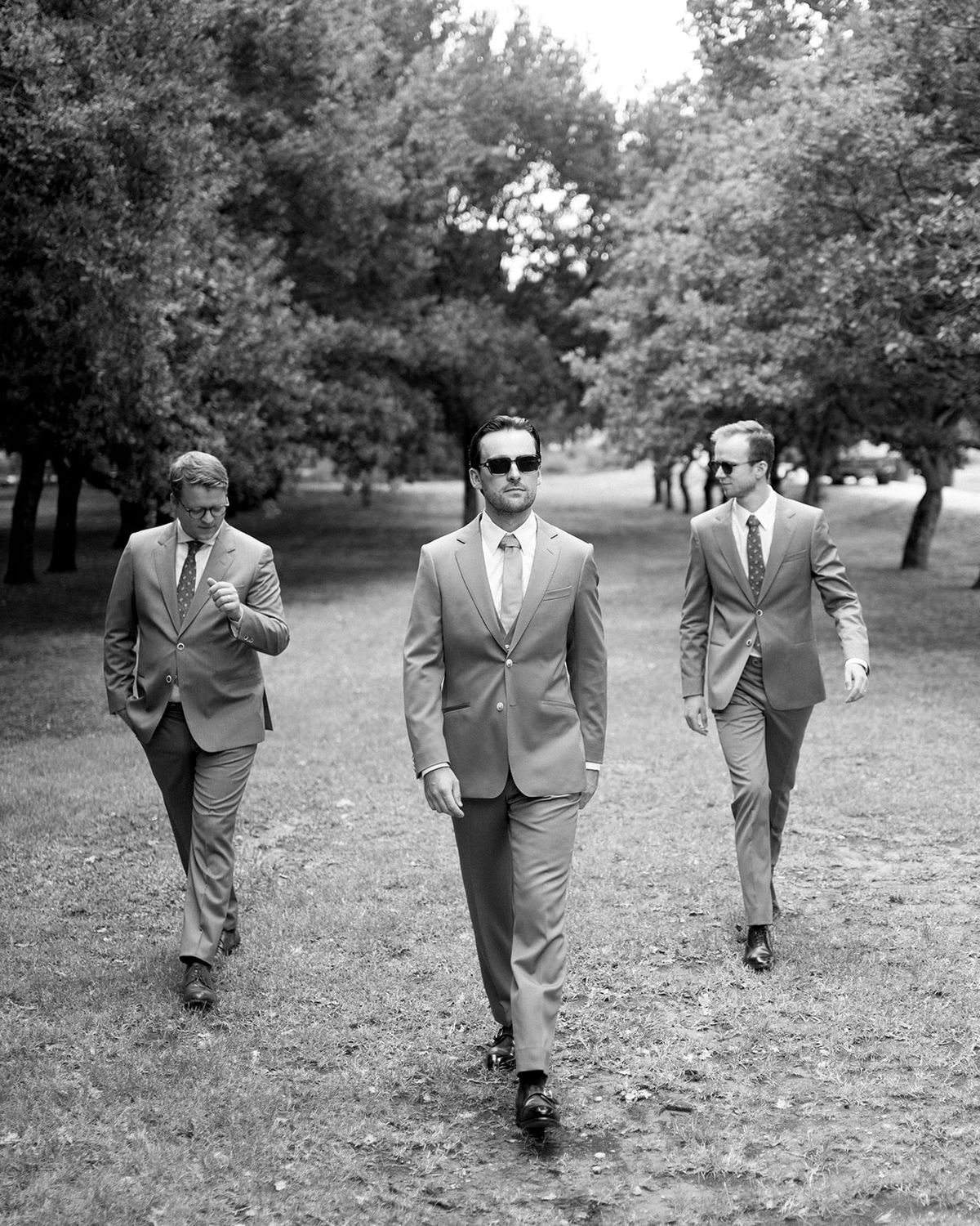 Groom walking with groomsmen through garden at Les Domaines de Patras, Provence
