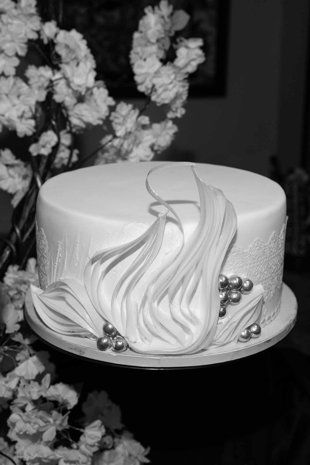 Sculptural white wedding cake with sugar ruffles and silver pearls at Parc Mougins