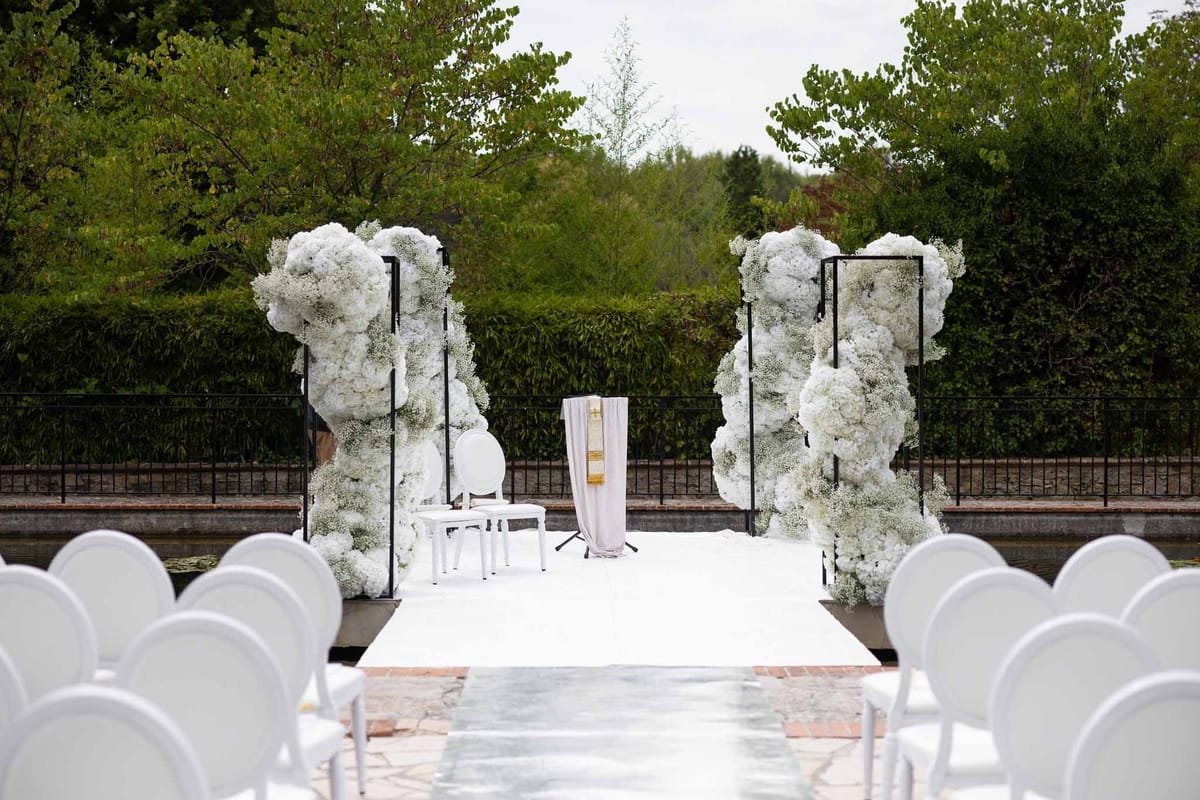 White hydrangea ceremony setup with mirrored aisle beside pool at Parc Mougins