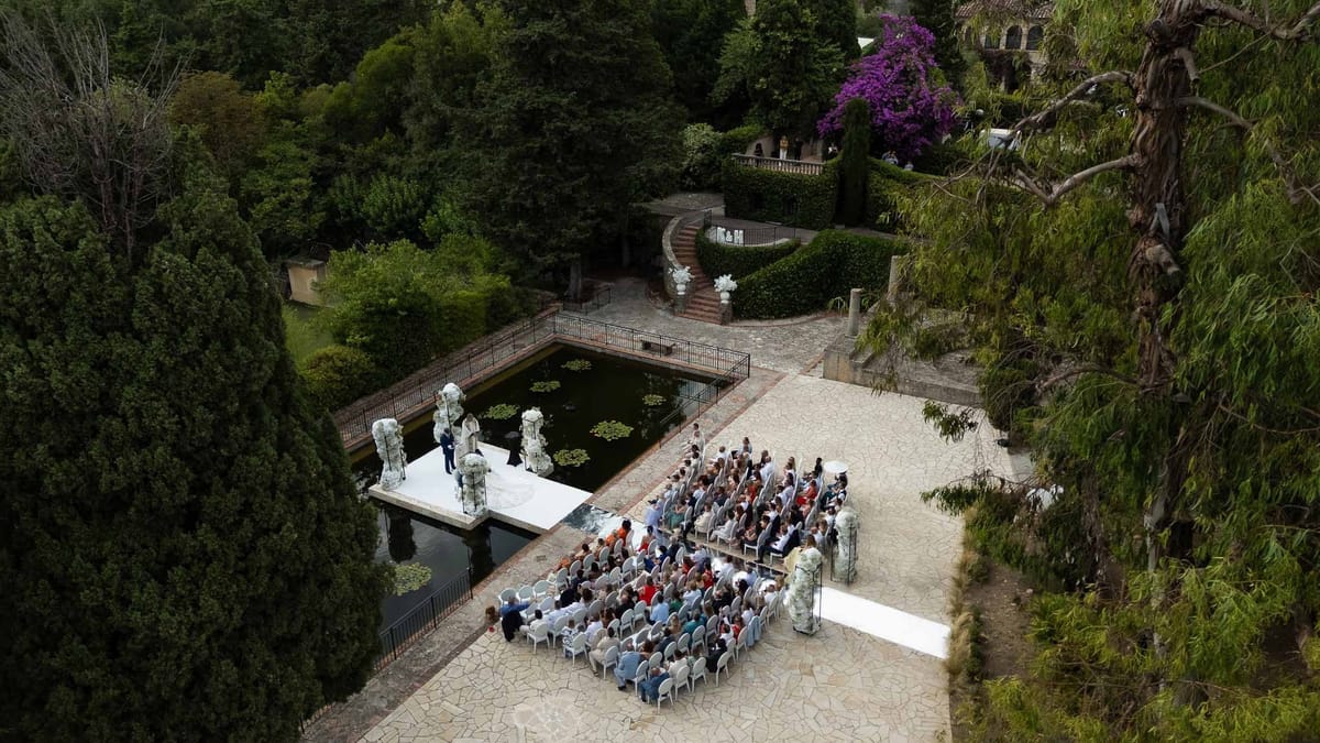 Aerial view of outdoor ceremony beside ornamental pond with guests at Parc Mougins