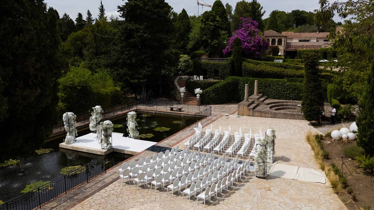 Elevated view of ceremony setup beside pond with statues and gardens at Parc Mougins