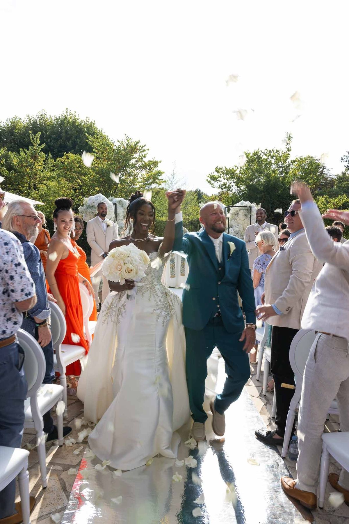 Couple celebrating during petal toss ceremony exit at Parc Mougins