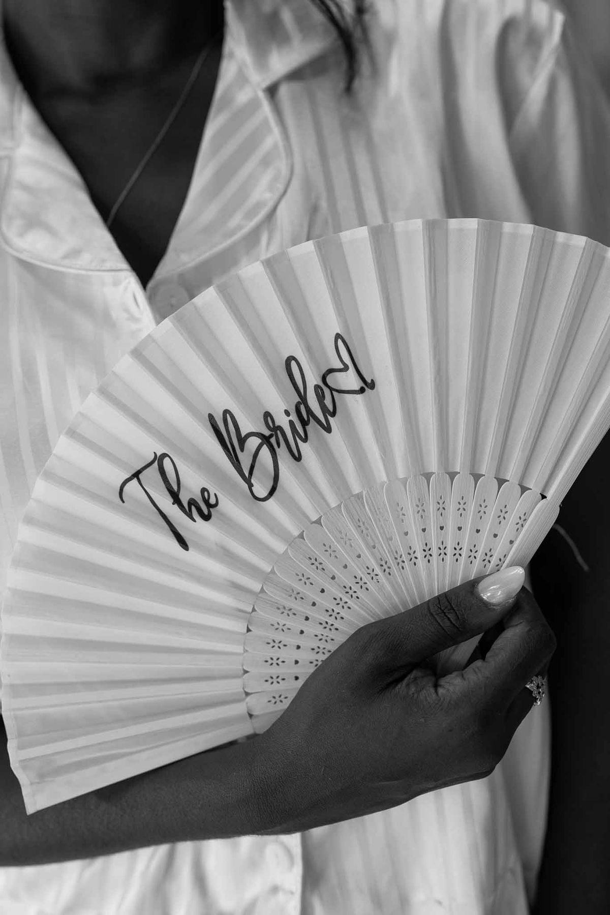 Bride holding personalised 'The Bride' hand fan in black and white at Parc Mougins