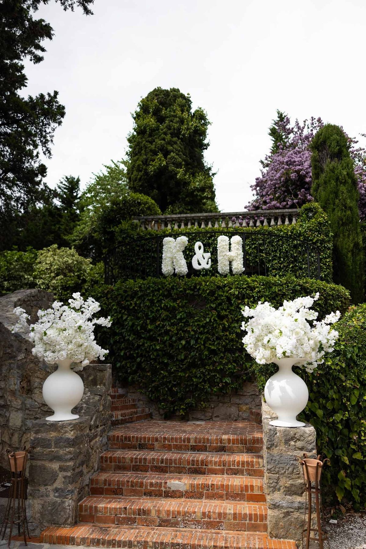 K&H floral monogram letters with hydrangea urns on garden steps at Parc Mougins