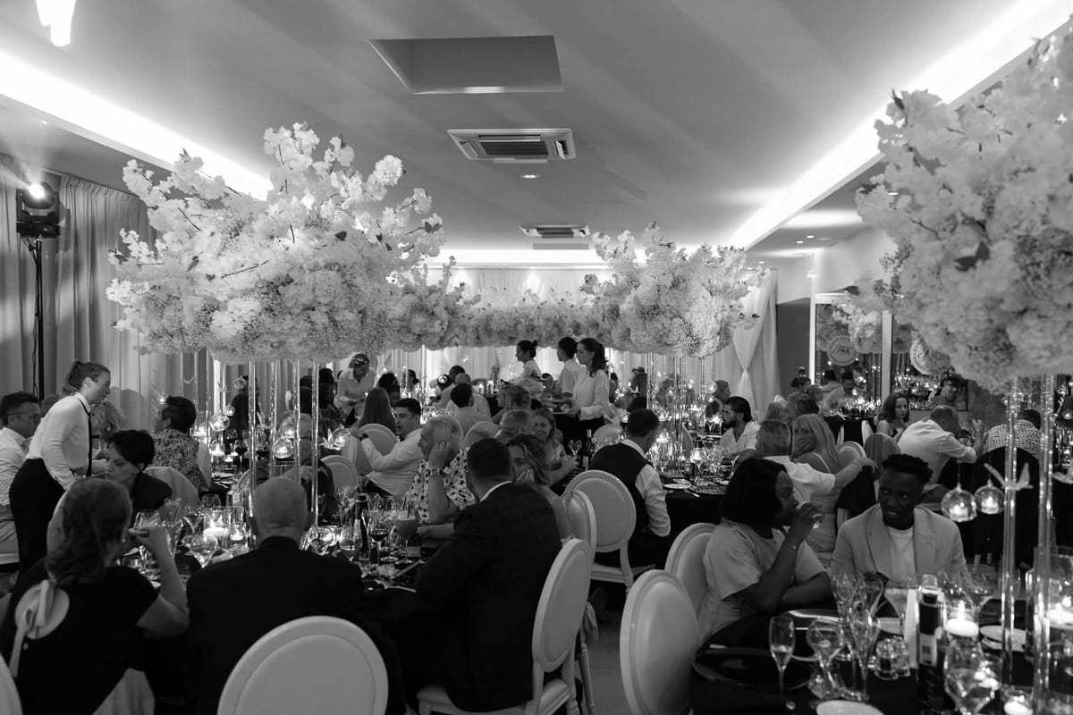 Guests at dinner with towering white floral centrepieces in black and white at Parc Mougins