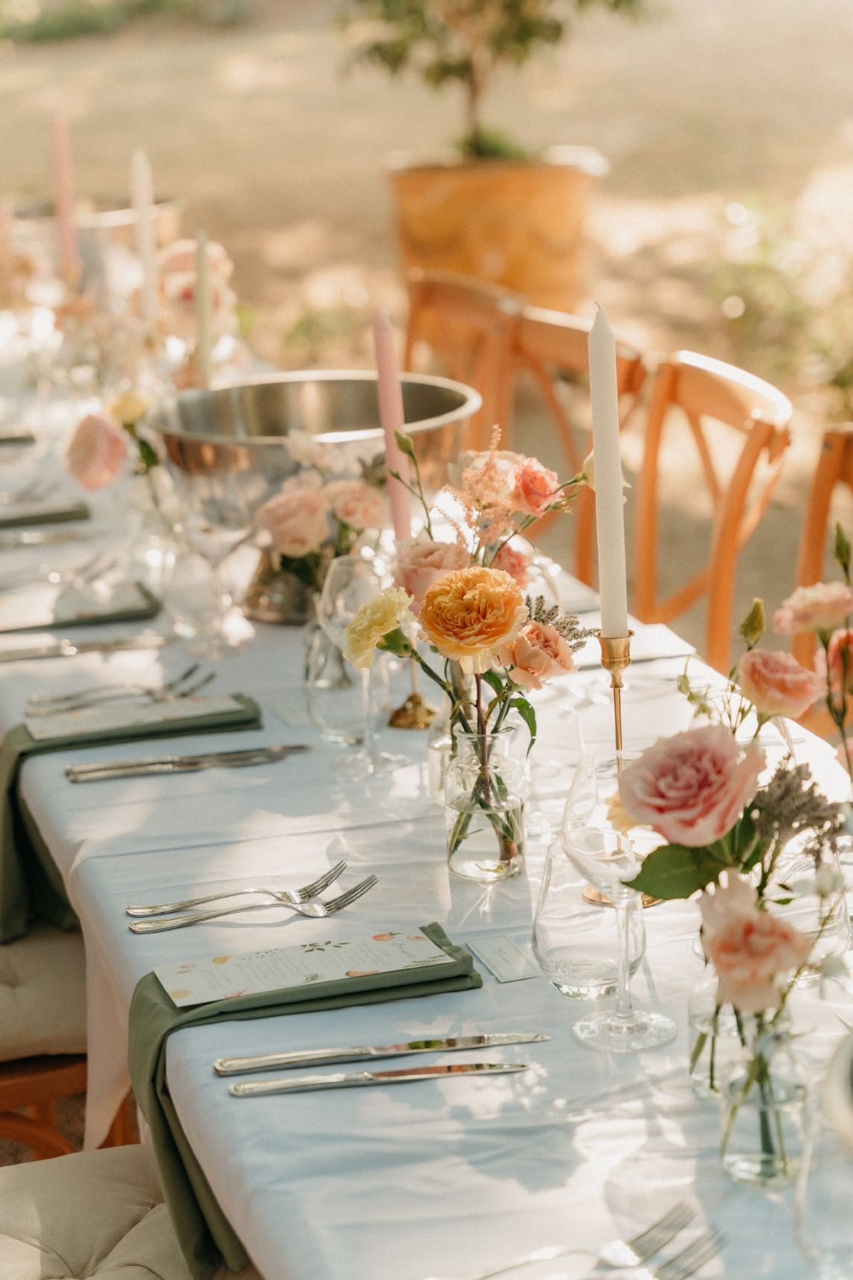 Long table detail with blush taper candles, bud-vase florals, silver coolers and sage napkins.