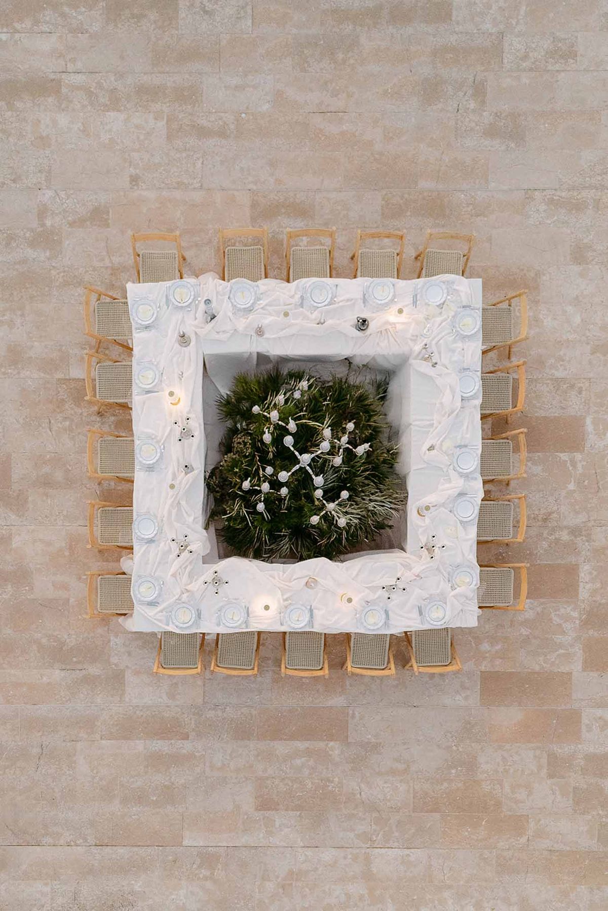 Aerial overhead view of hollow-square table with dense fern greenery center and rattan chairs