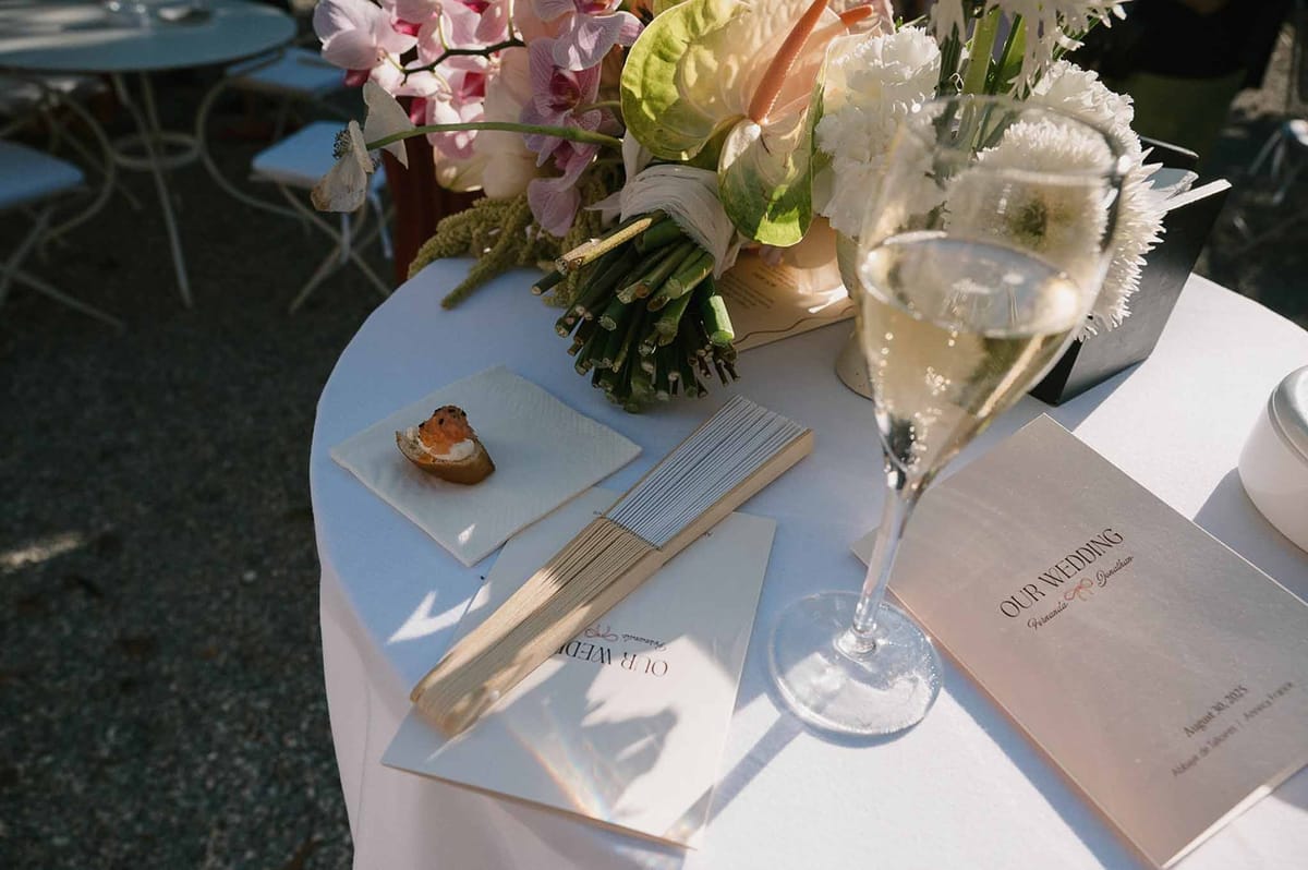Cocktail table with bouquet, hand fans and champagne at Abbaye de Talloires
